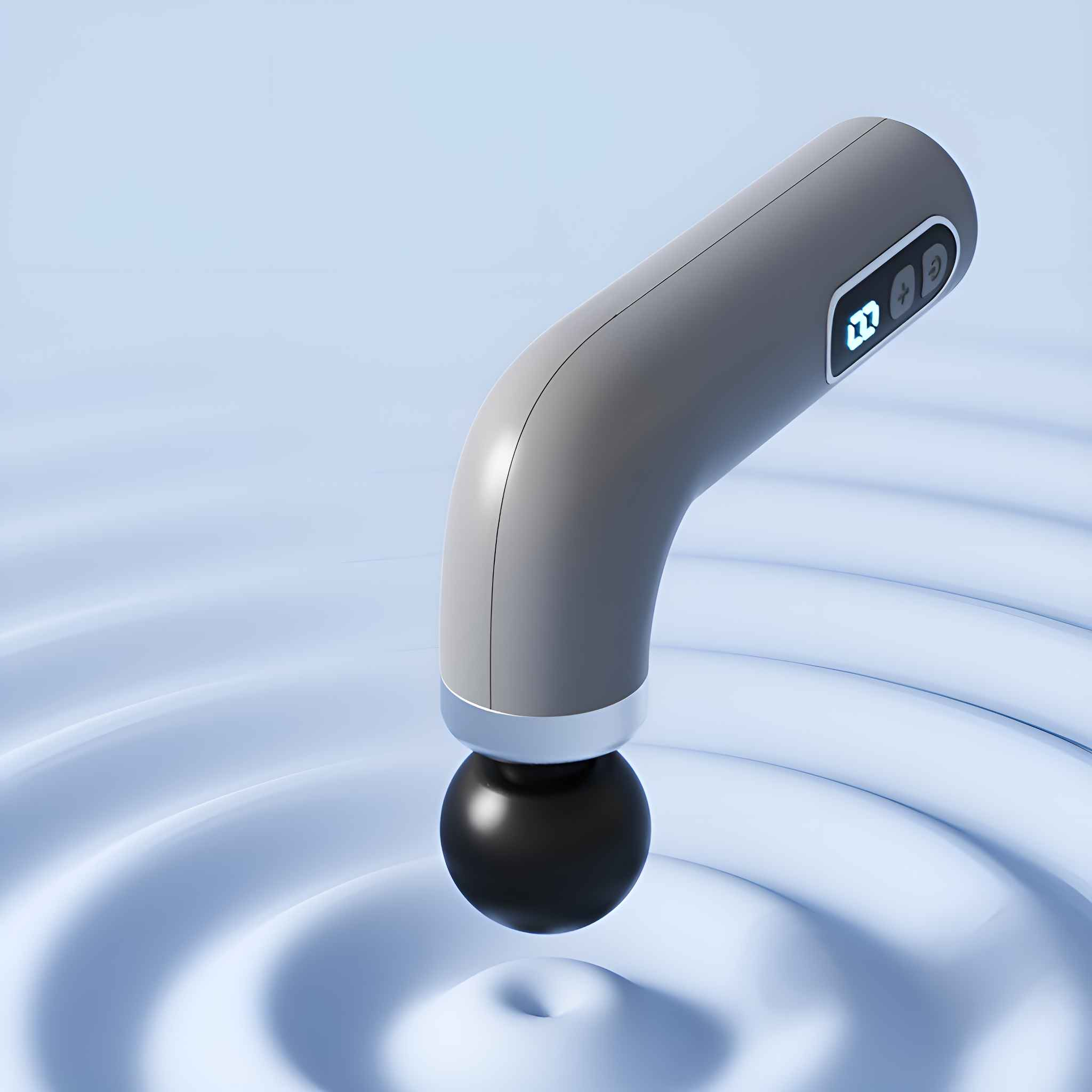 Eine graue Massagepistole mit schwarzem Massagekopf, die in Wasser mit Kräuselungen platziert ist.