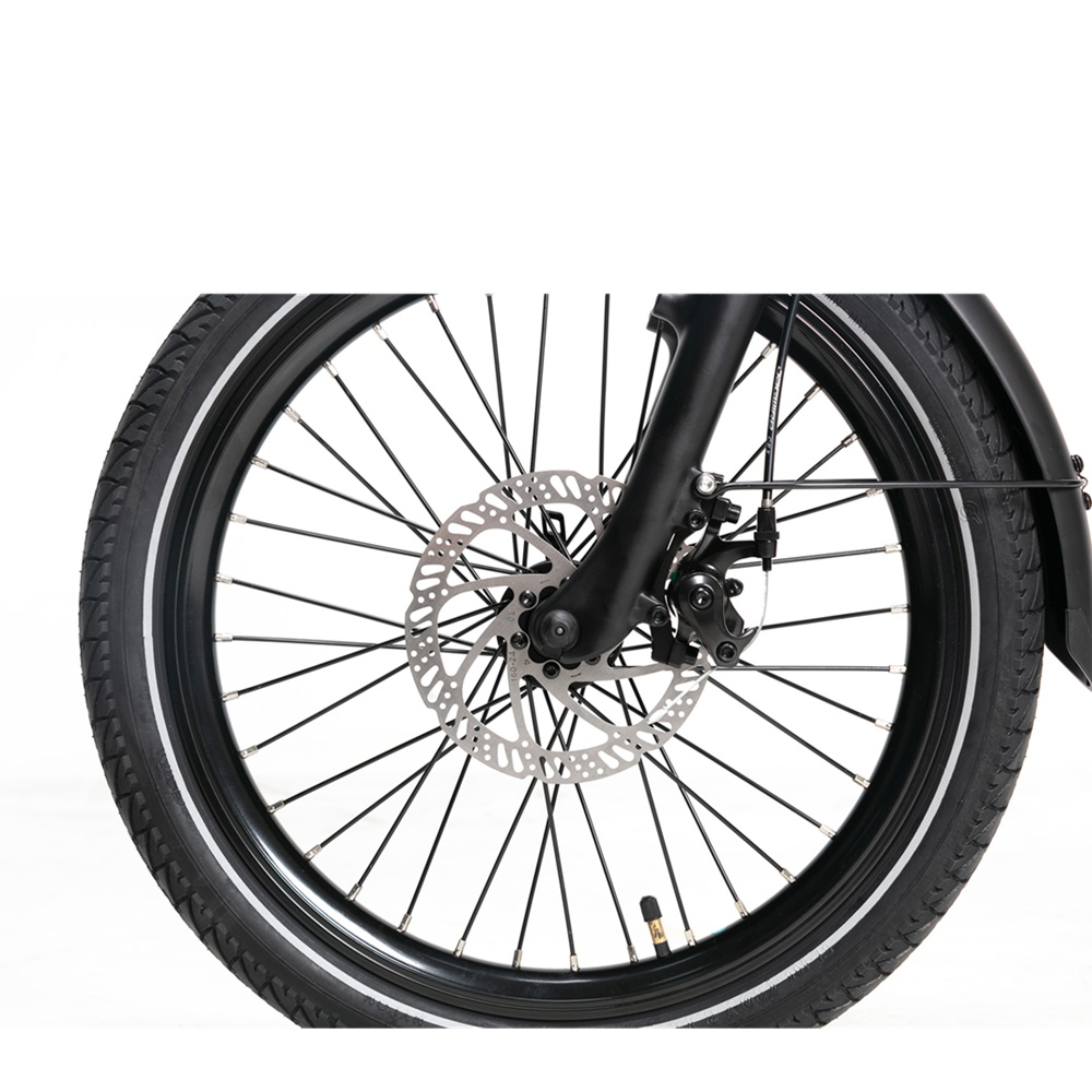 Primo piano di una ruota di bicicletta nera con freno a disco. Lo sfondo è bianco.