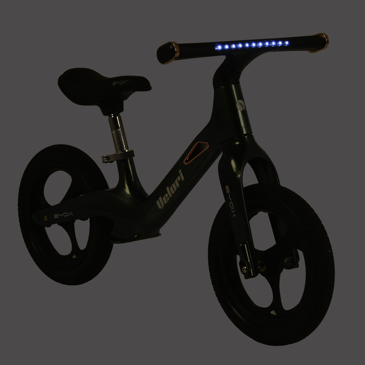 Ein schwarzes Laufrad mit LED-Leuchten am Lenker, aufgenommen vor einem dunklen Hintergrund.