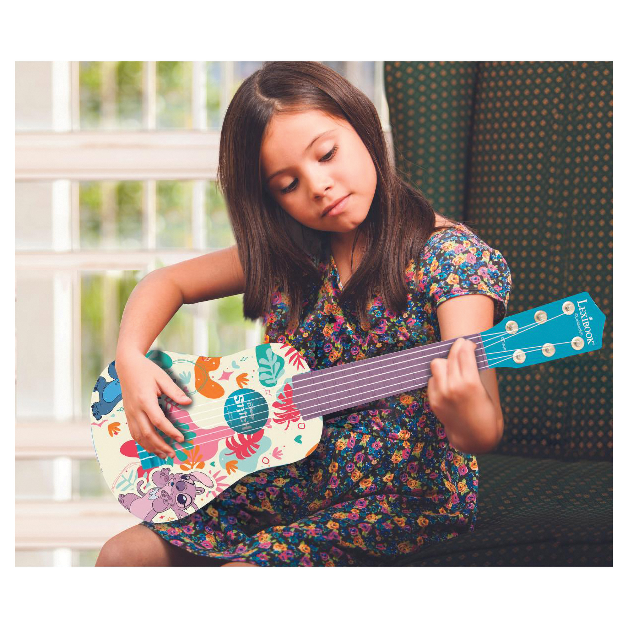 Ein Mädchen spielt in einem hellen Raum eine Ukulele mit Stitch- und Angel-Motiven.