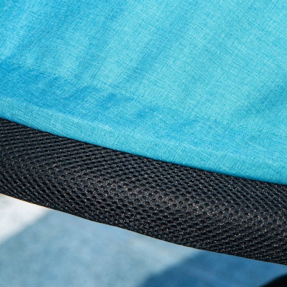 Nahaufnahme eines türkisfarbenen Stoffes mit einem schwarzen Netzmaterial.