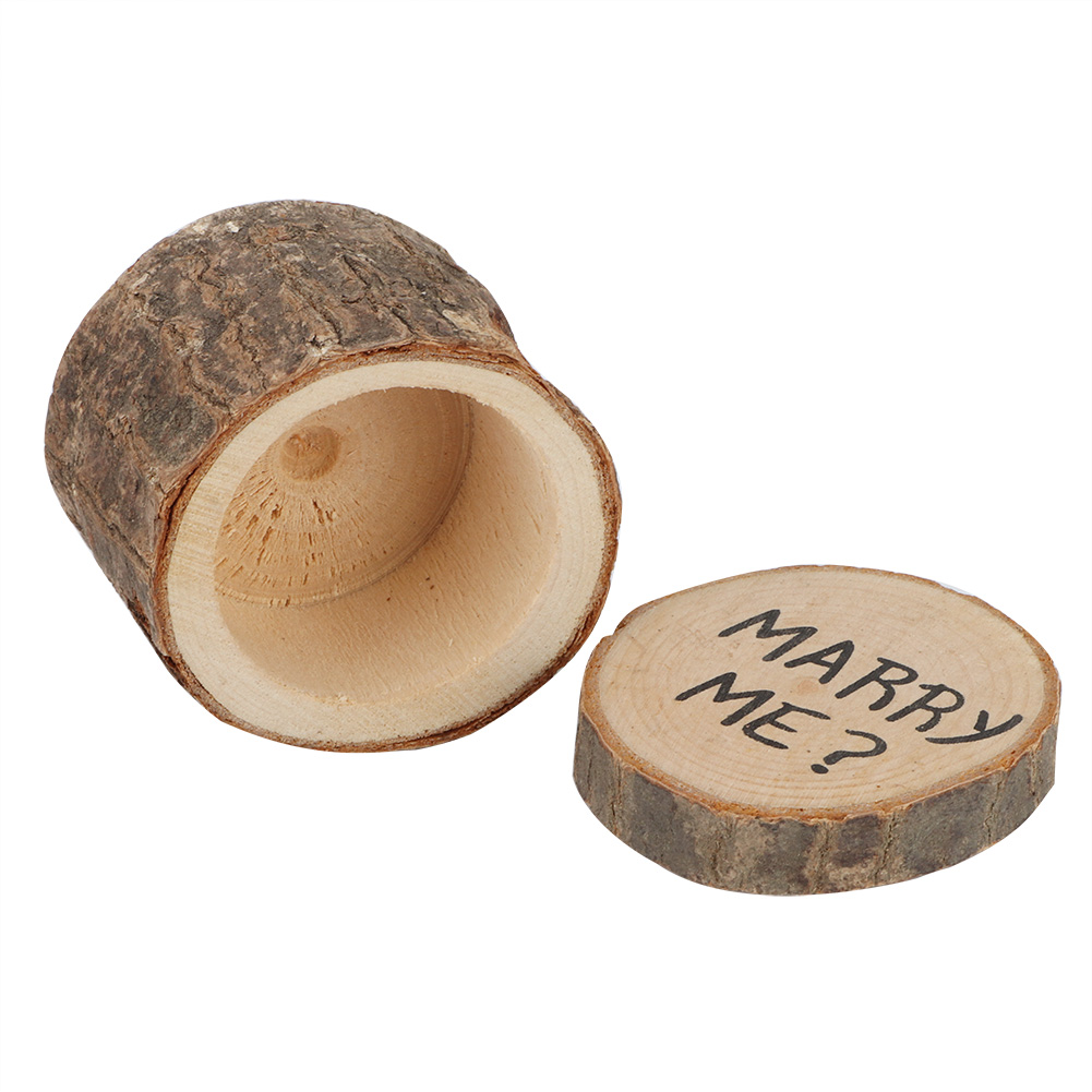 Eine hölzerne Ringbox, geöffnet, mit einem Deckel, auf dem 'MARRY ME?' steht. Die Box ist aus Holz gefertigt.
