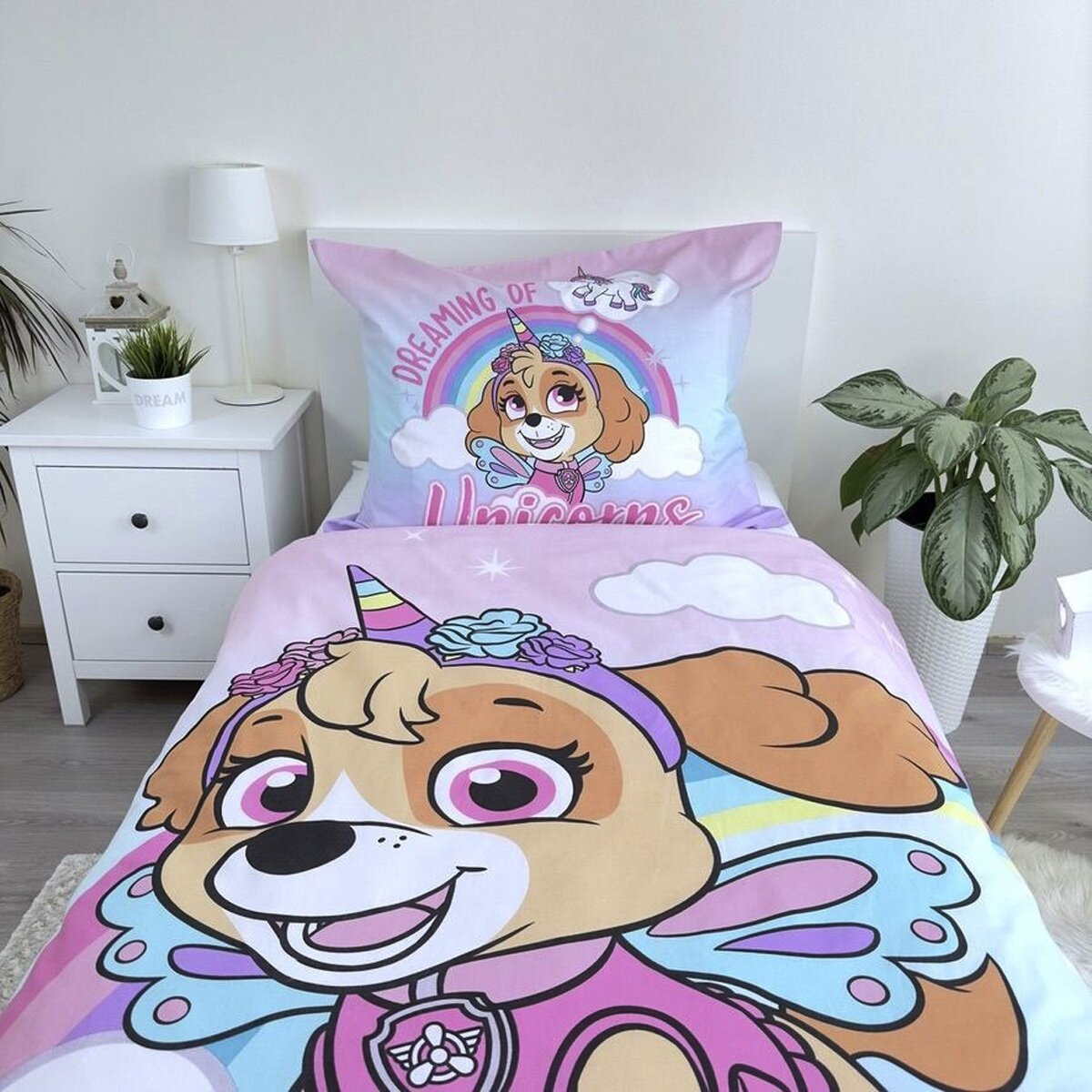 Bettwäsche-Set mit Skye von Paw Patrol als Einhorn. Mit einem weißen Nachttisch und einer grünen Pflanze.