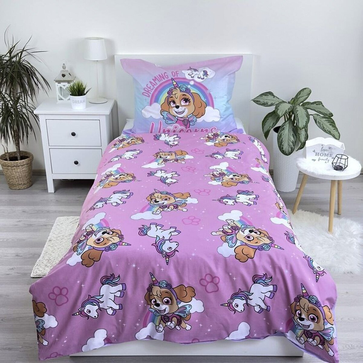 Bettwäsche-Set mit Skye von Paw Patrol als Einhörner. Mit einem weißen Nachttisch und einem kleinen weißen Teppich.