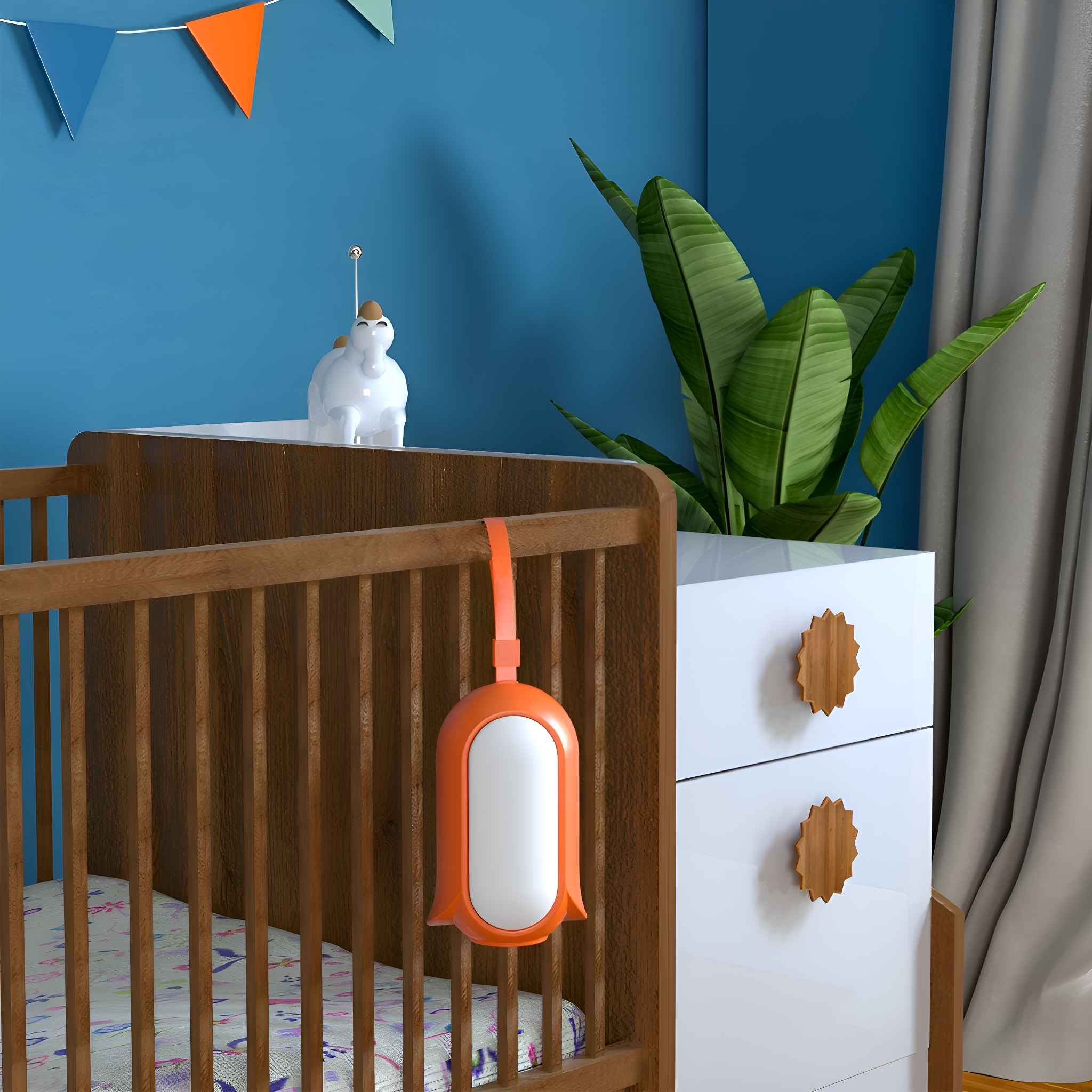 Ein Babybett mit einem Mobile und einer Kommode mit einer Pflanze und einem dekorativen Gegenstand.