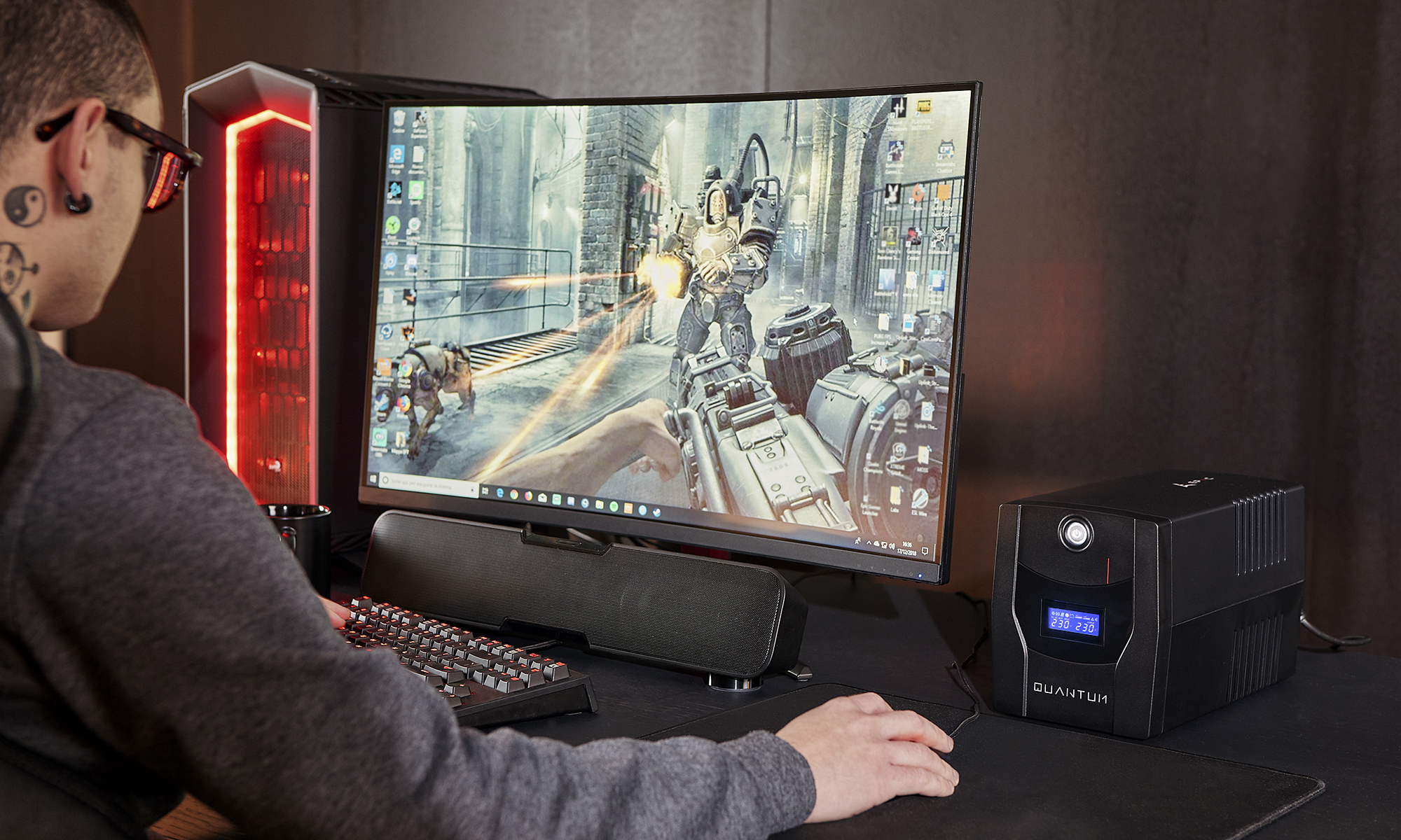Una persona che gioca a un gioco su un computer con un UPS, monitor e tastiera.