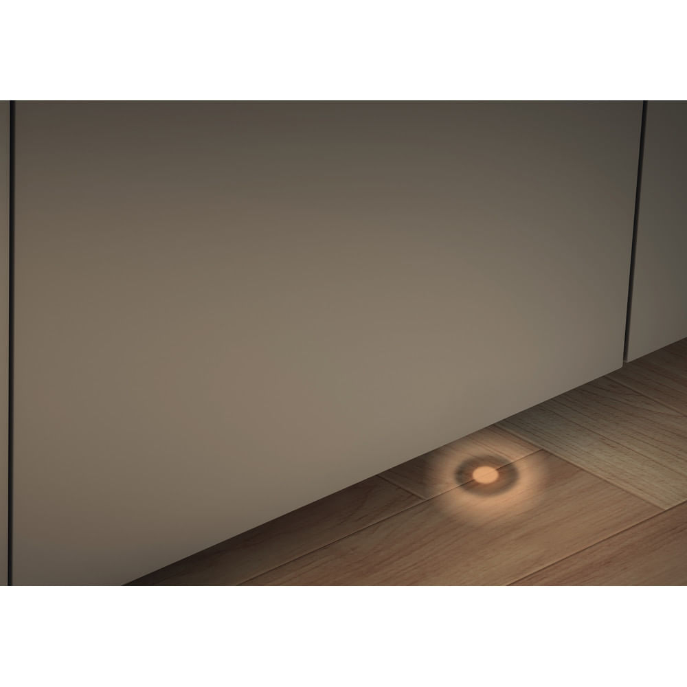 Una lavastoviglie è aperta, rivelando l'interno. La porta è beige, in tinta con i mobili circostanti. È visibile un pannello di controllo.