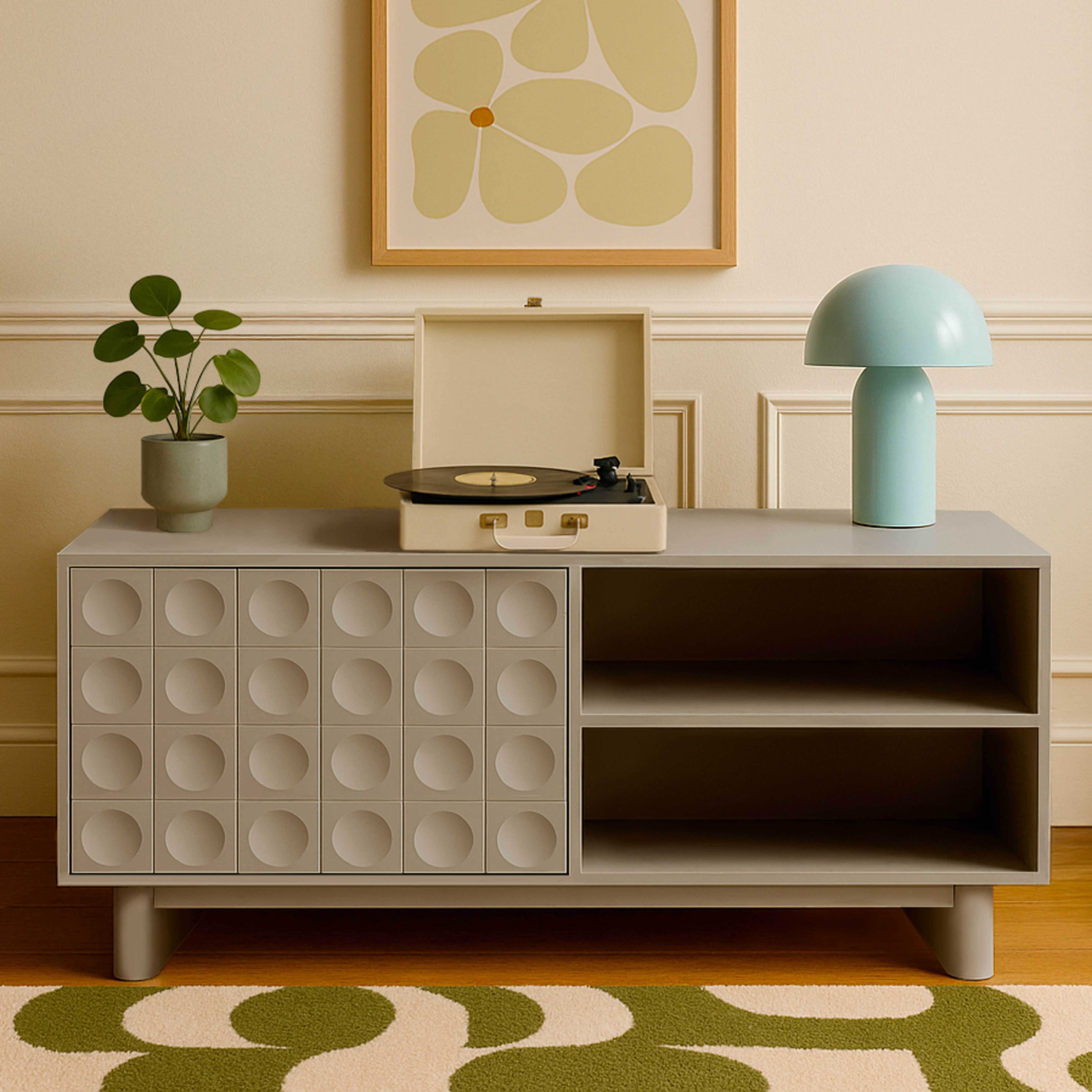 Wohnzimmer mit Holzkommode, Pflanzen, gerahmter Kunst und gemütlichen Möbeln.