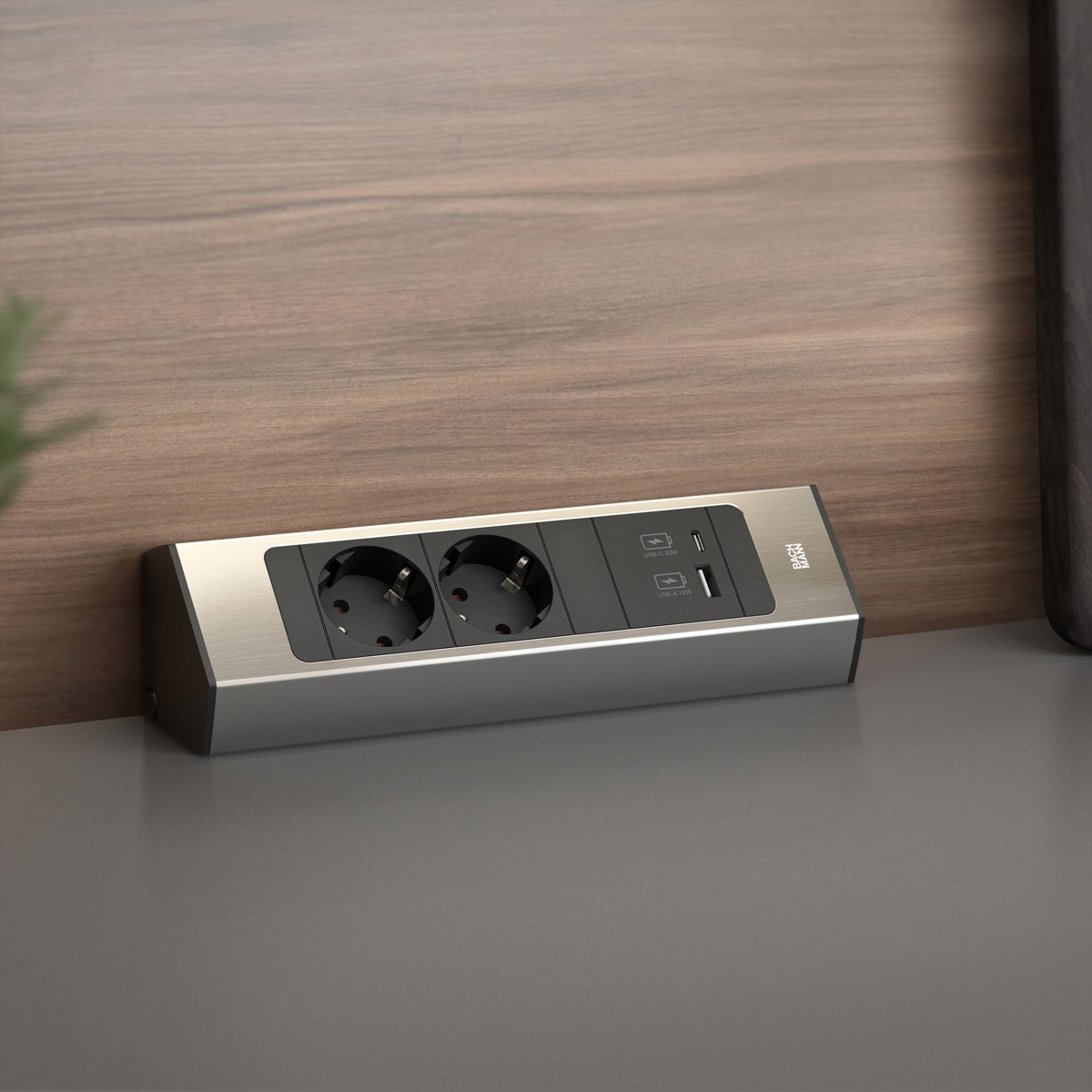 Zilver stopcontact geïntegreerd in een aanrecht, met twee stopcontacten en USB-poorten.