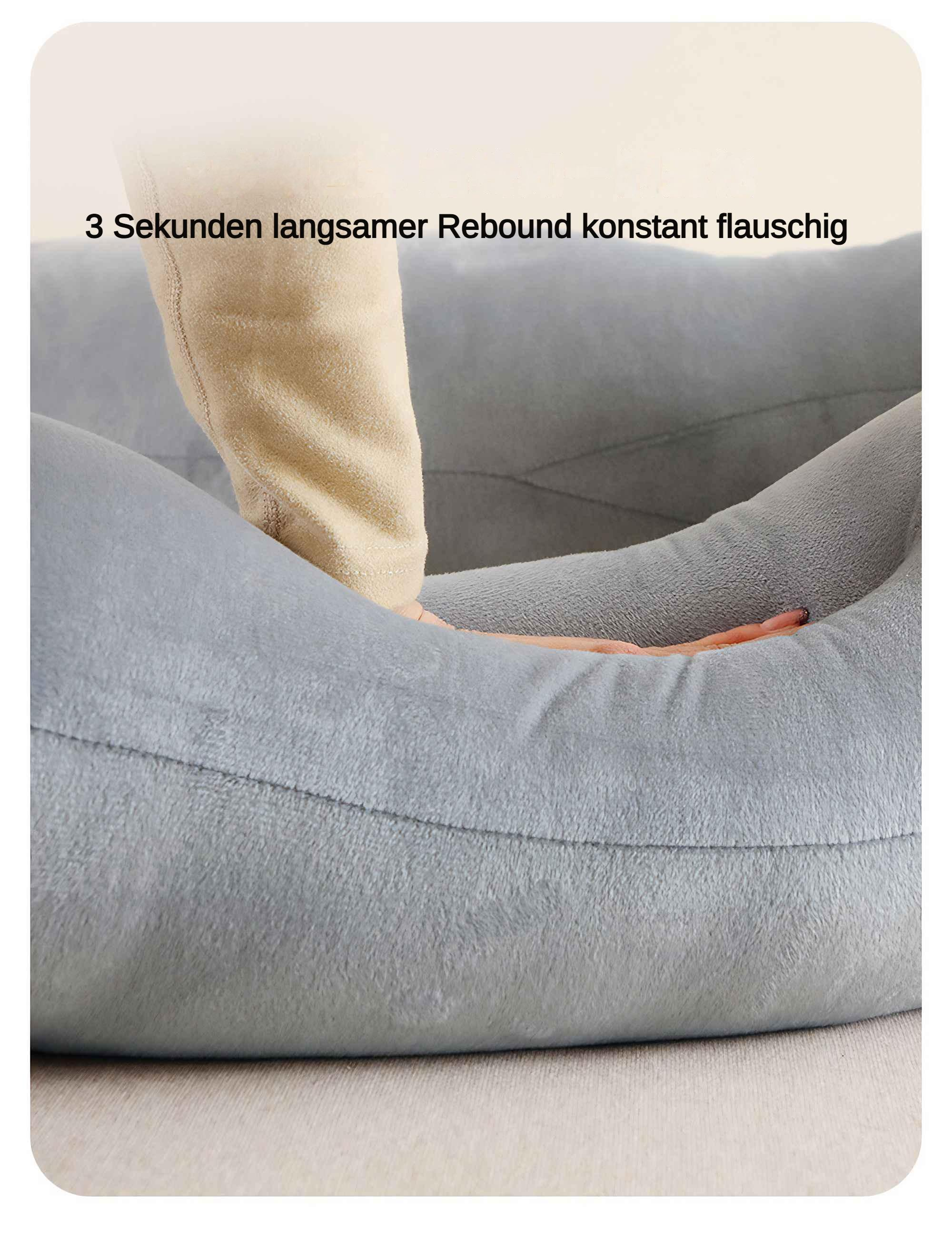 Nahaufnahme eines grauen Kissens mit einer Hand, die hineindrückt, um seine weiche Textur zu zeigen.