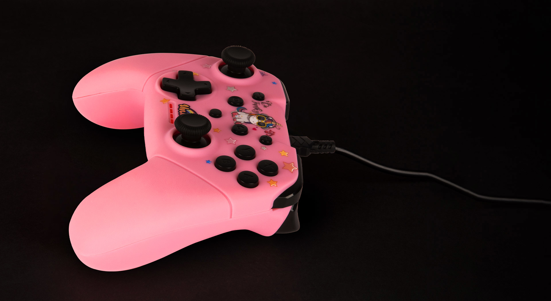 Un controller rosa con un design a unicorno e pulsanti neri su sfondo nero.