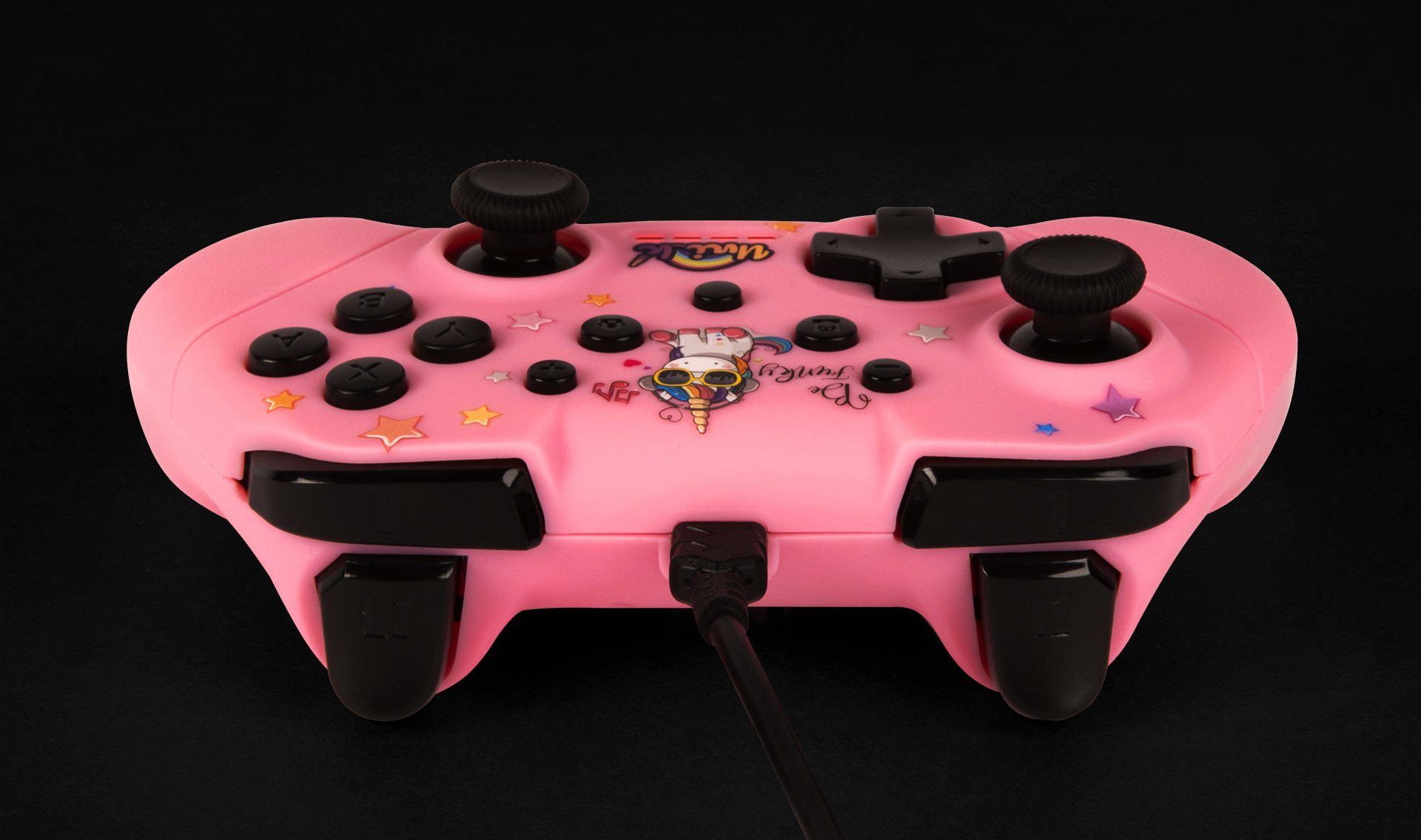 Un controller rosa con un design a unicorno e pulsanti neri su sfondo nero.