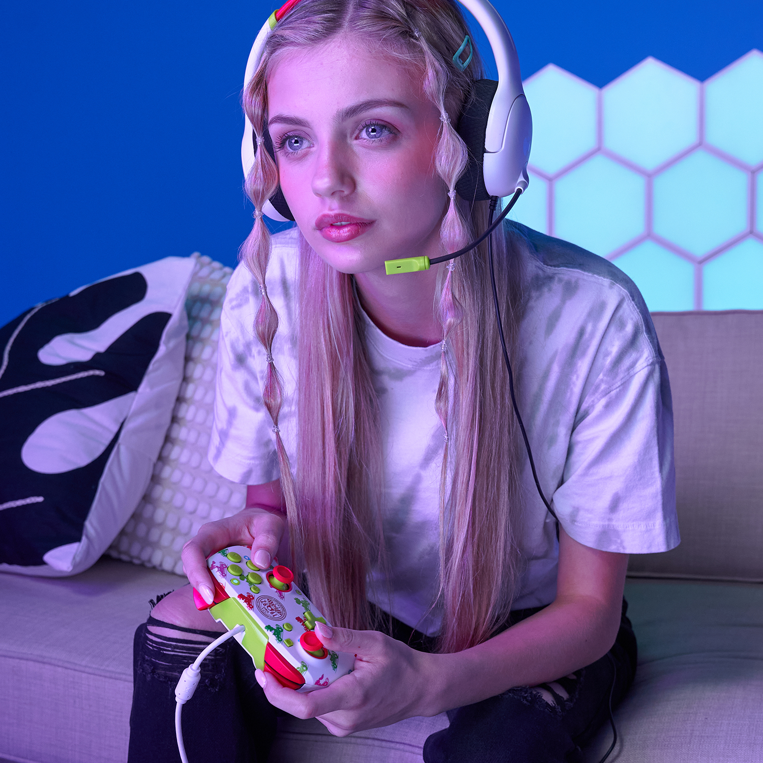 Kobieta z zestawem słuchawkowym gra z kontrolerem. Niebieska ściana i światła.