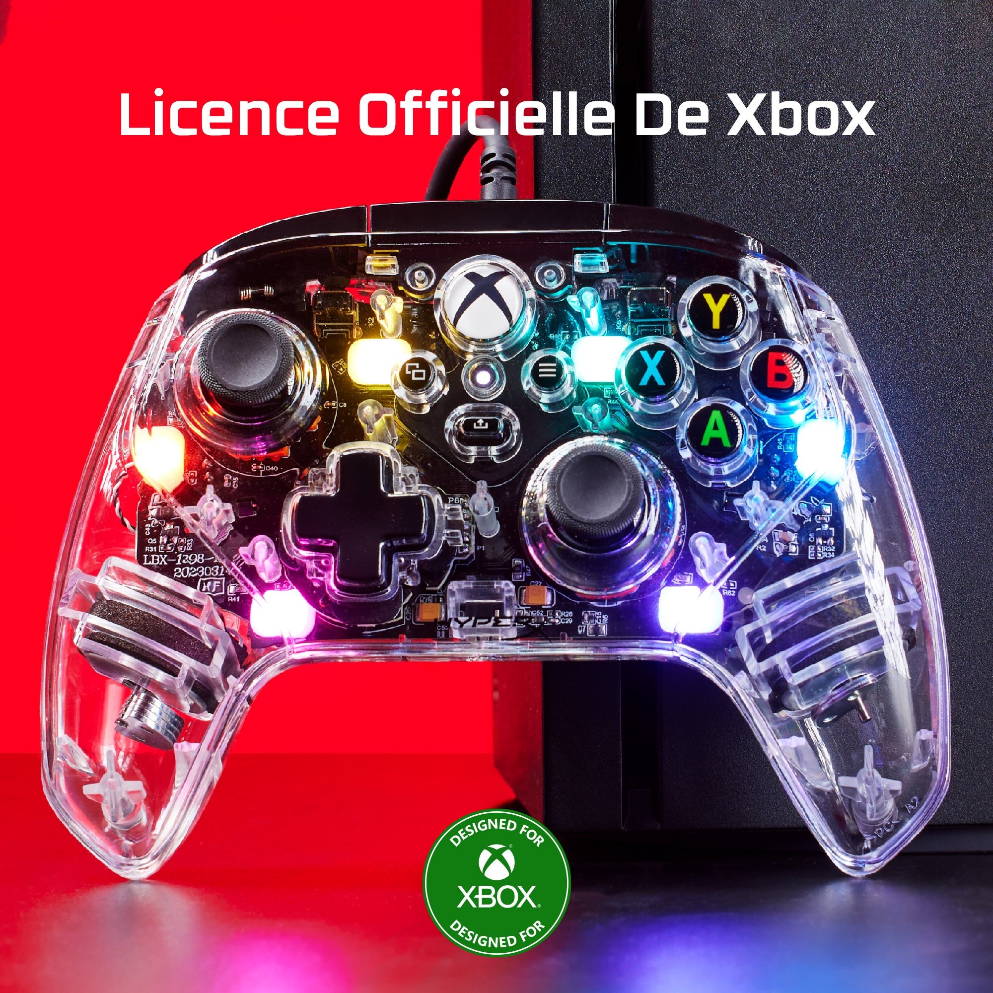 Przezroczysty kontroler Xbox ze światłami, tekstem 'Licence Officielle De Xbox' i logo Xbox.