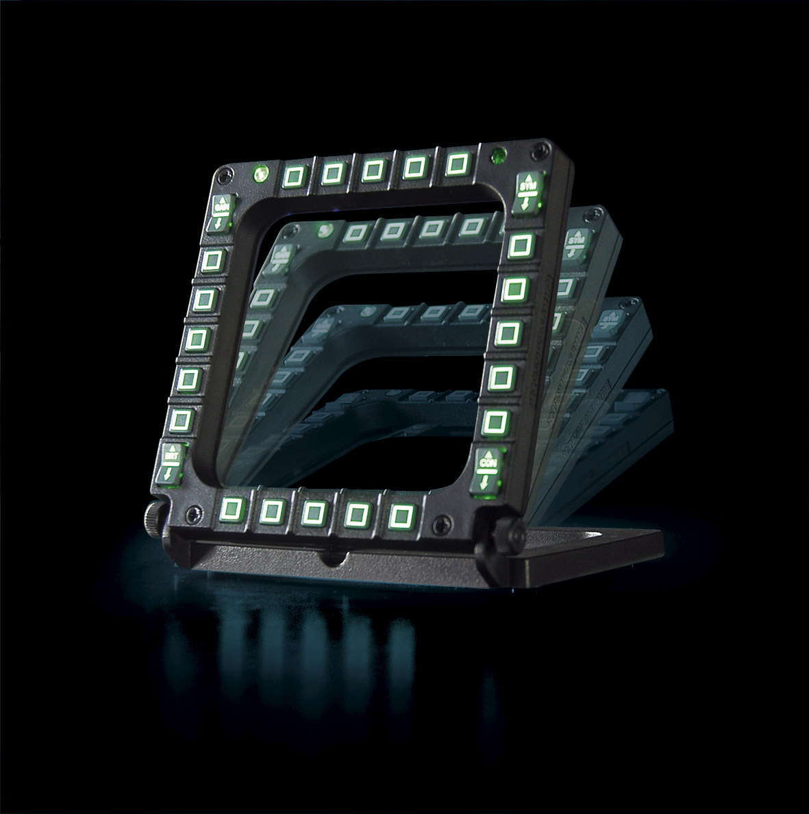 Una vista angolata di un dispositivo nero con una serie di pulsanti quadrati con luci ed etichette verdi.