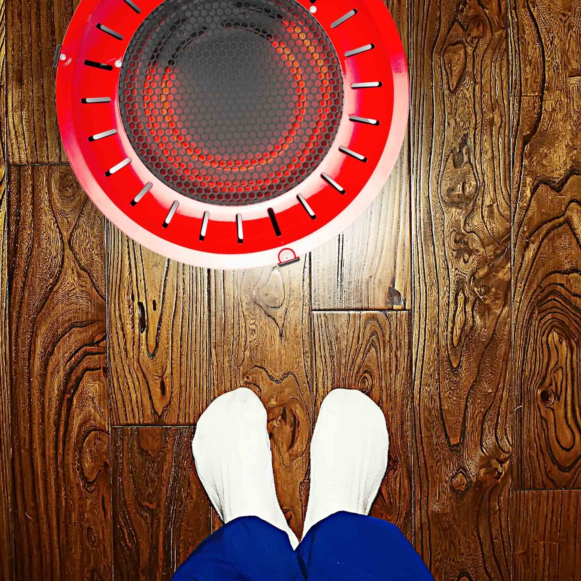 Vista dall'alto di un termostato elettrico rosso con elemento riscaldante esposto. Calzini bianchi e pantaloni blu in primo piano.