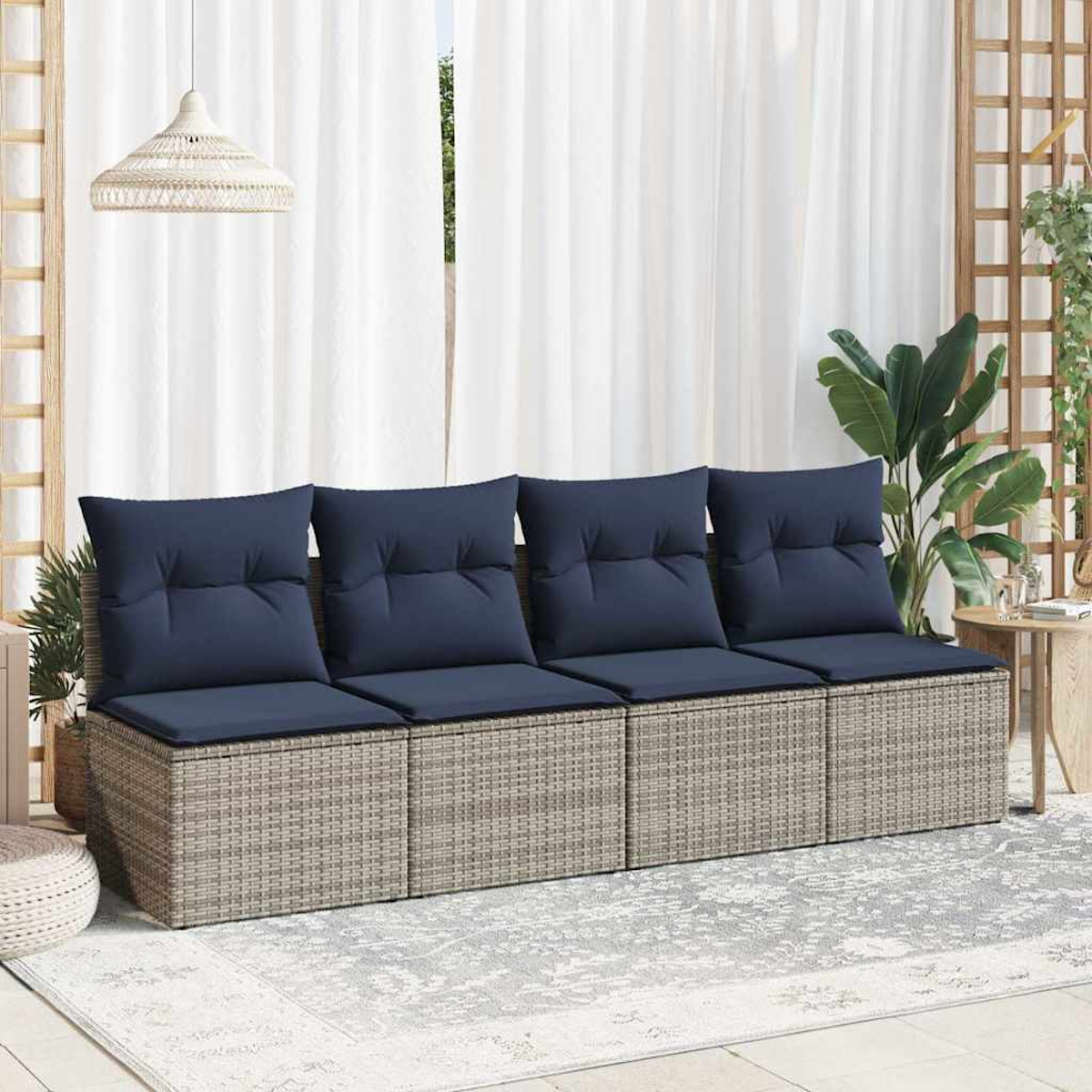 Ein Rattan-Sofaset mit blauen Kissen auf einem Teppich, mit weißem Vorhanghintergrund.