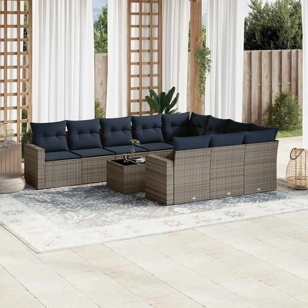Terrassenset mit Stühlen im Rattan-Stil und einem Ecksofa mit blauen Kissen. Vorhänge und Teppich.