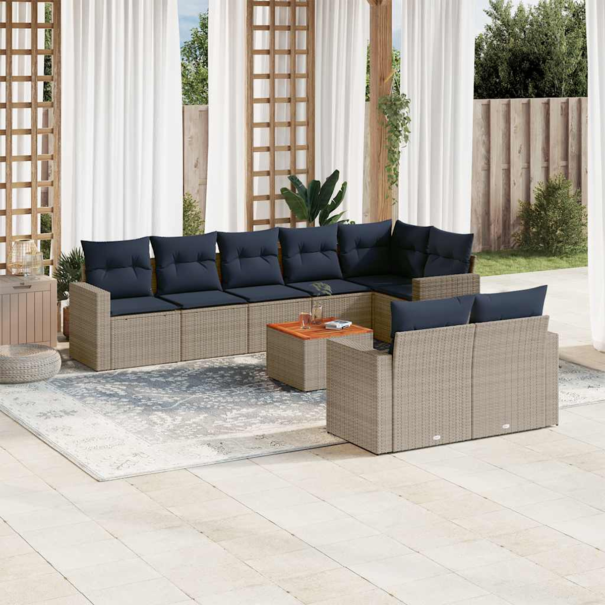 Conjunto de asientos al aire libre con sofá, mesa y cojines azules. Tonos neutros en un patio de piedra.