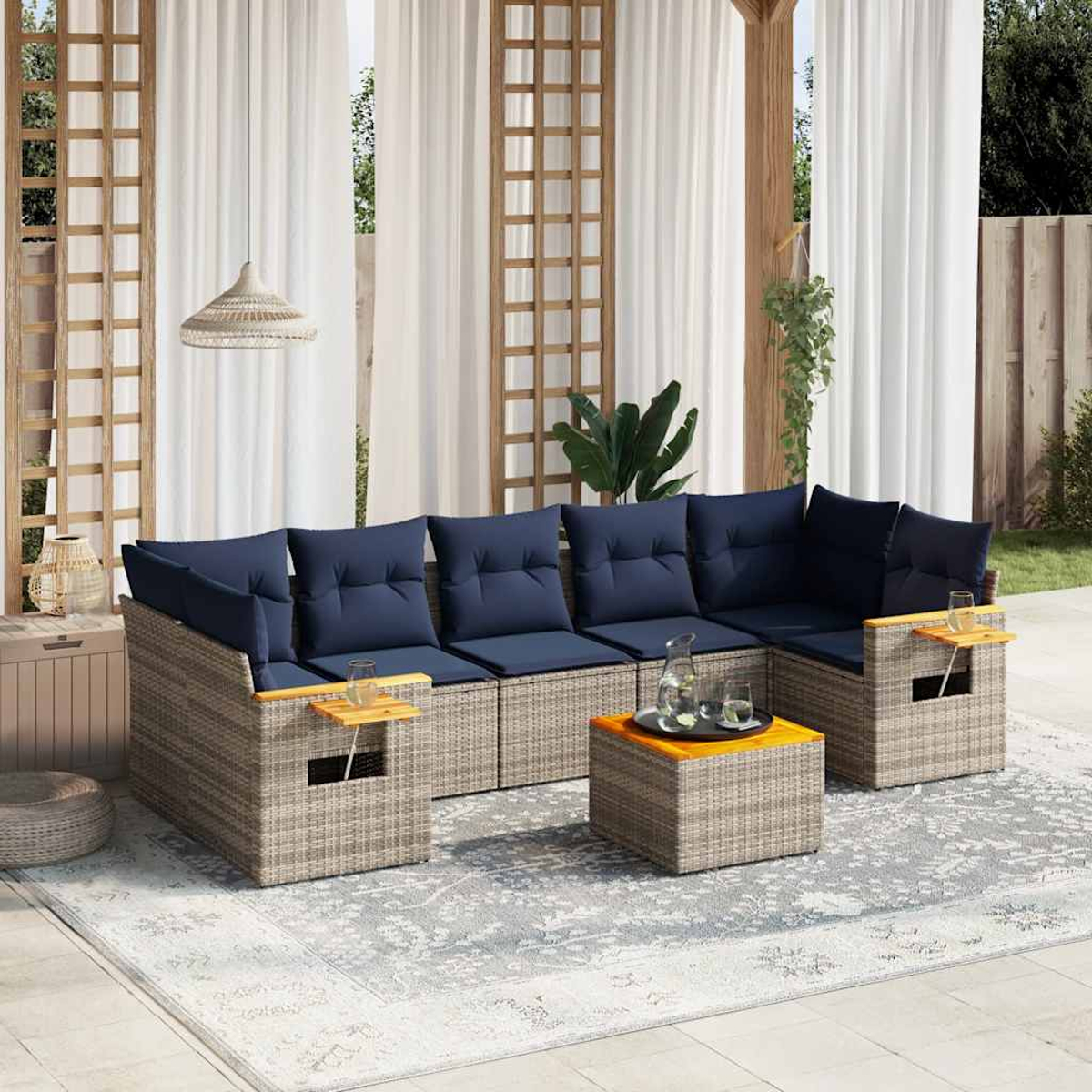 Outdoor-Terrassen-Ecksofa mit grauem Weidengeflecht, blauen Kissen und quadratischem Tisch. Weiße Vorhänge und Teppich.