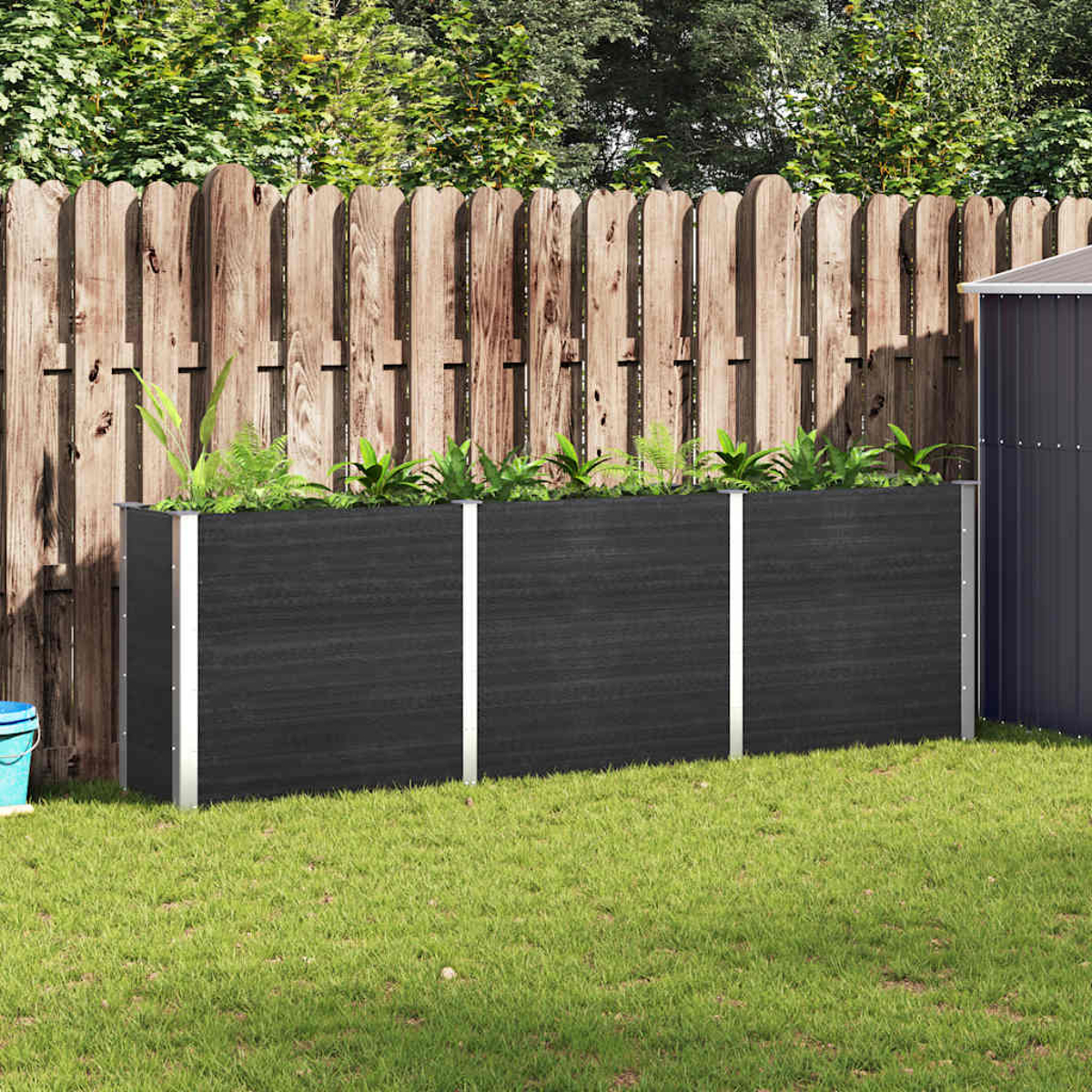 Eine Gartenszene mit Holzzaun, Gras und drei dunklen Pflanzgefäßen. Ein Schuppen rechts.