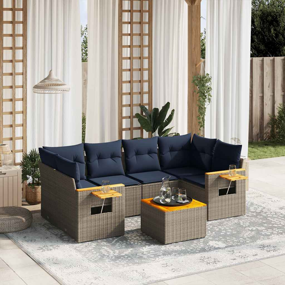 Conjunto de sofás de ratán para exteriores con cojines azules sobre una alfombra gris. Una mesa con vasos está en la escena.