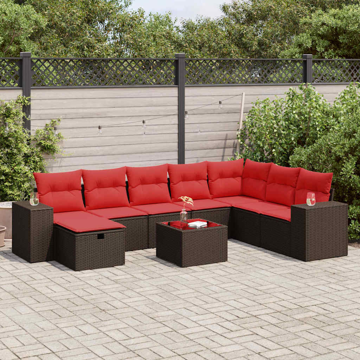 Outdoor-Ecksofa mit roten Kissen auf einer Terrasse. Braune Korbmöbel.