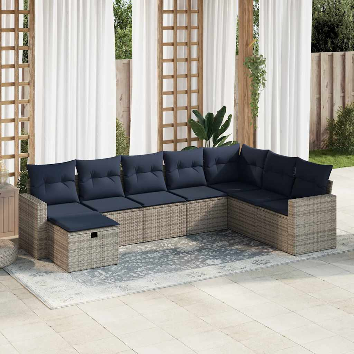 Outdoor-Ecksofa mit marineblauen Kissen. Beige Korbmöbel, weiße Vorhänge und Holzstruktur.