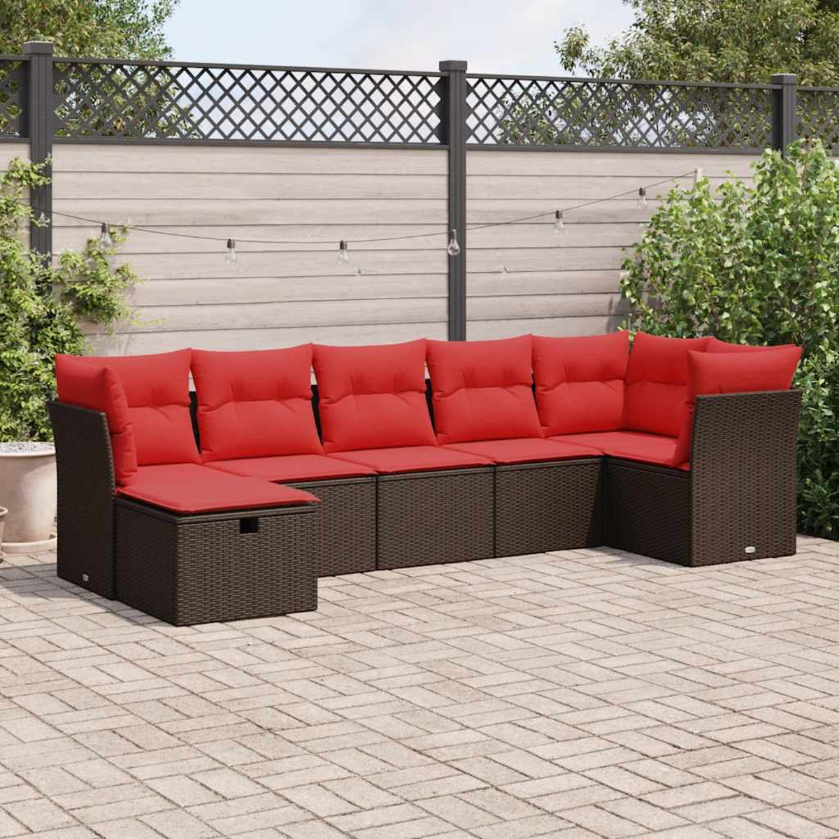 Outdoor-Ecksofa mit roten Kissen. Braune Korbmöbel auf einer Terrasse.