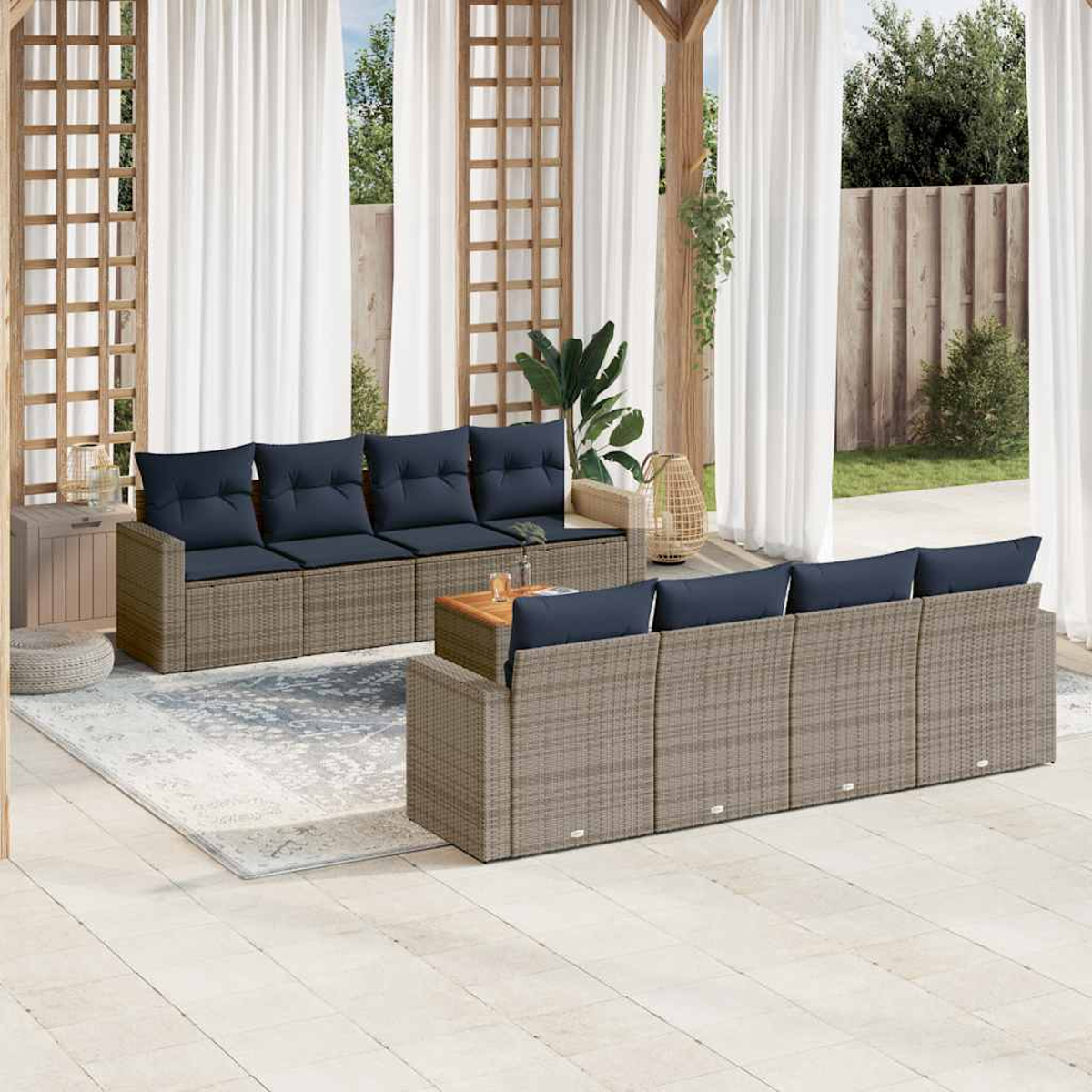 Terrassen-Setting mit zwei Sofas. Rattanrahmen, blaue Kissen, Tisch.