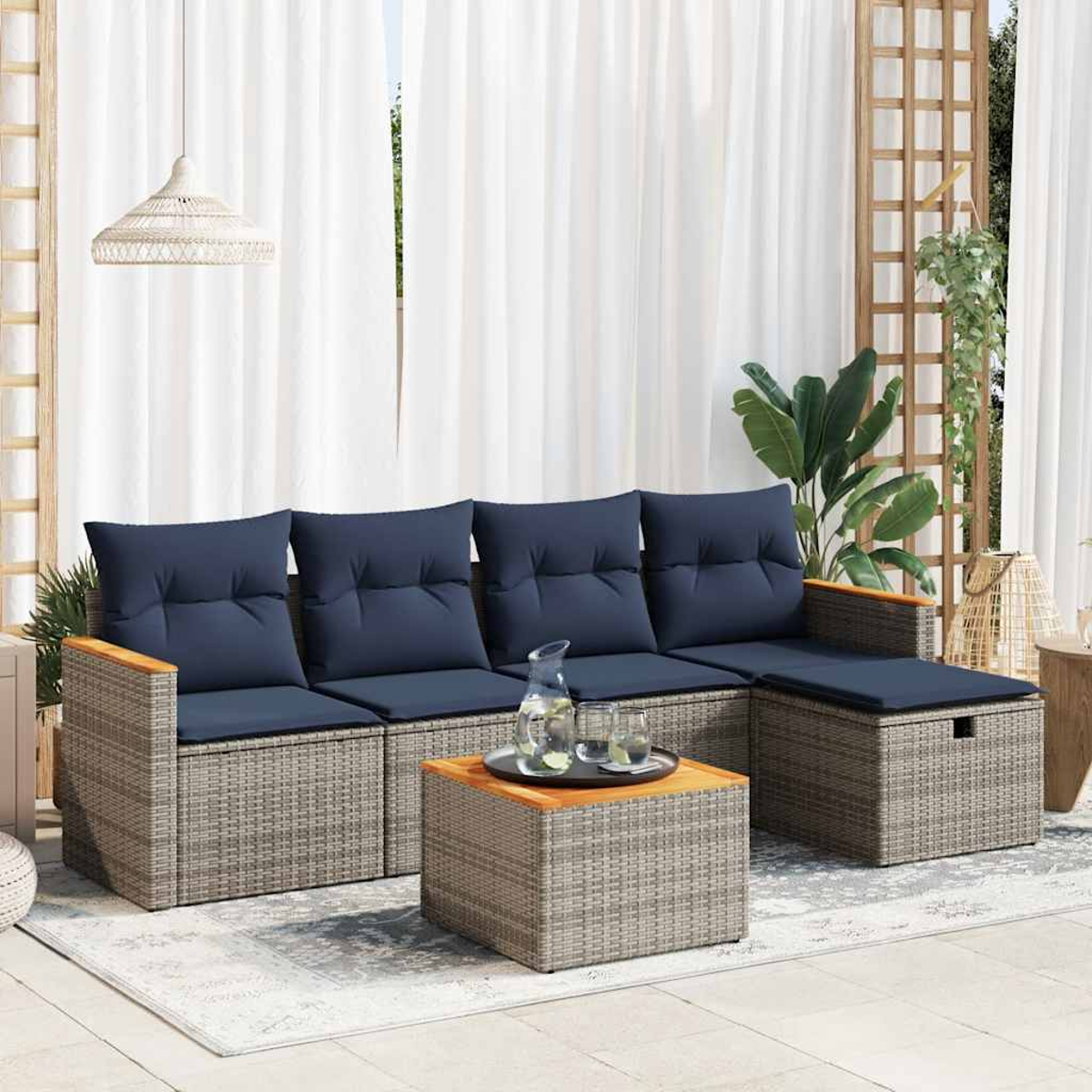 Gartenmöbel-Set mit Sofa, Ottomane und Couchtisch. Graues Korbgeflecht, blaue Kissen und weißer Hintergrund.