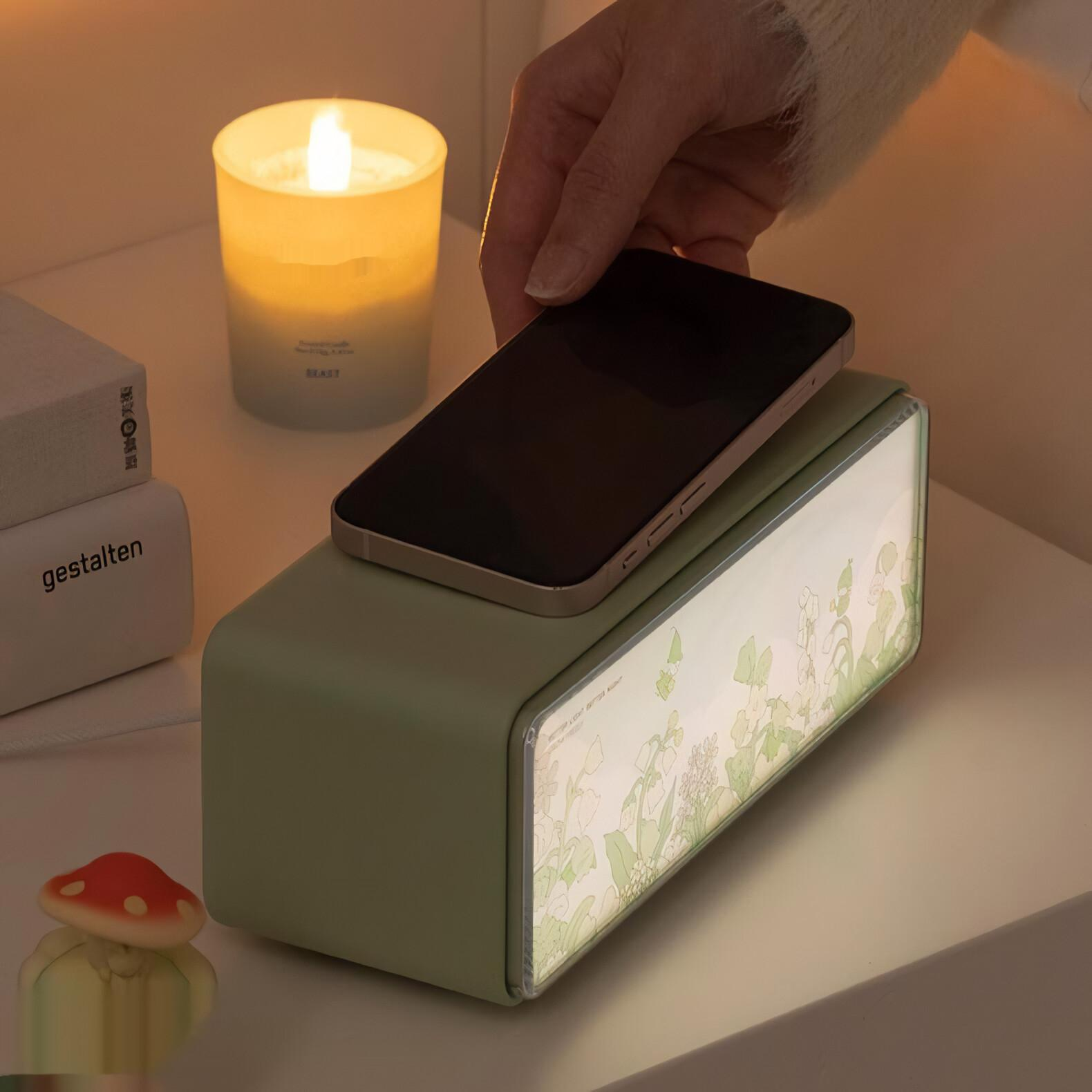 Eine brennende Kerze, ein Telefon auf einer Box und ein pilzförmiges Objekt auf einem Nachttisch, weißer Hintergrund.
