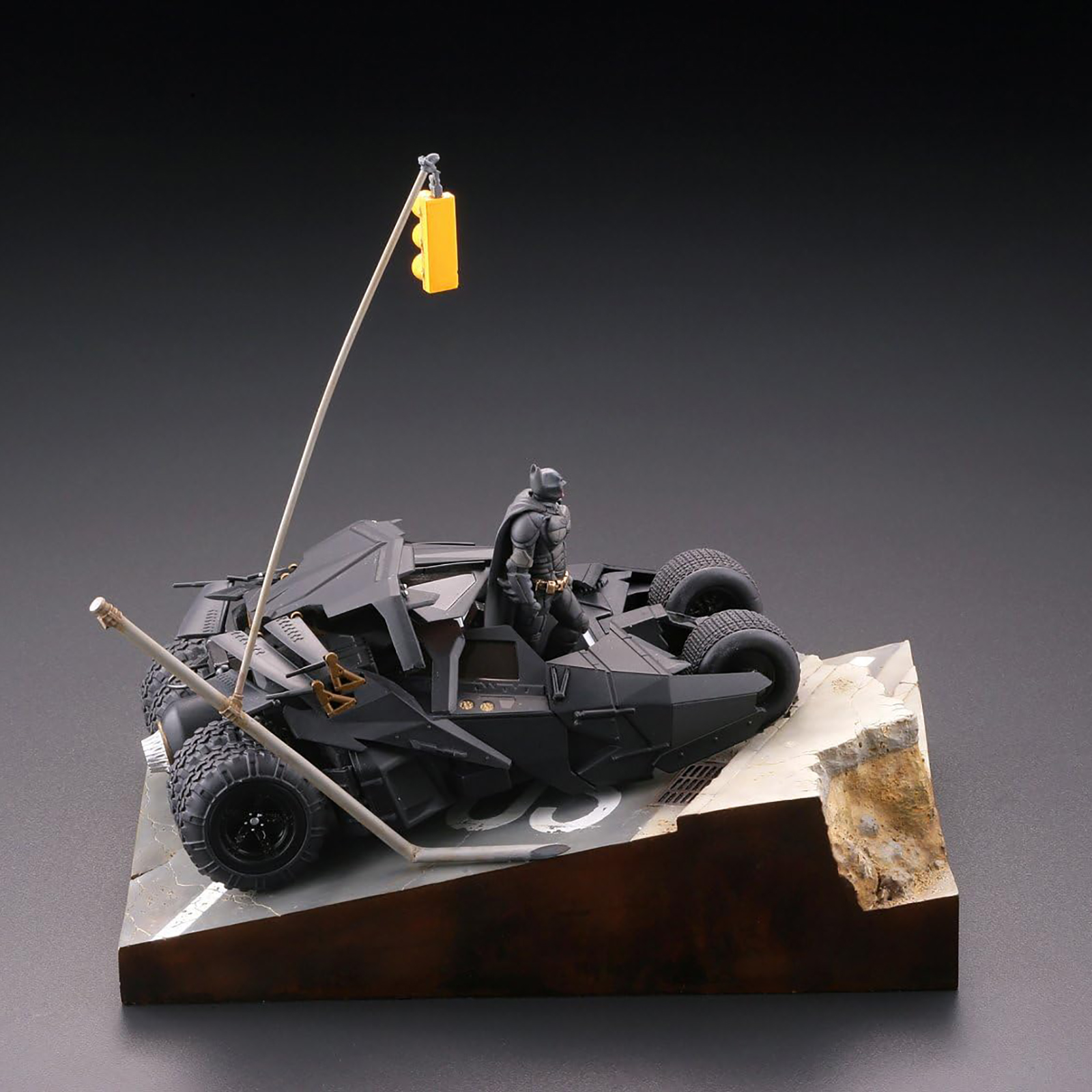 Ein Modell eines Batmobils mit Batman-Figur, auf einem Diorama mit einer Ampel.