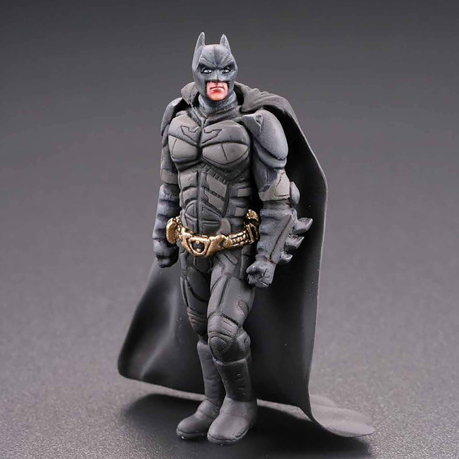 Eine Batman-Actionfigur steht mit einem Umhang da.