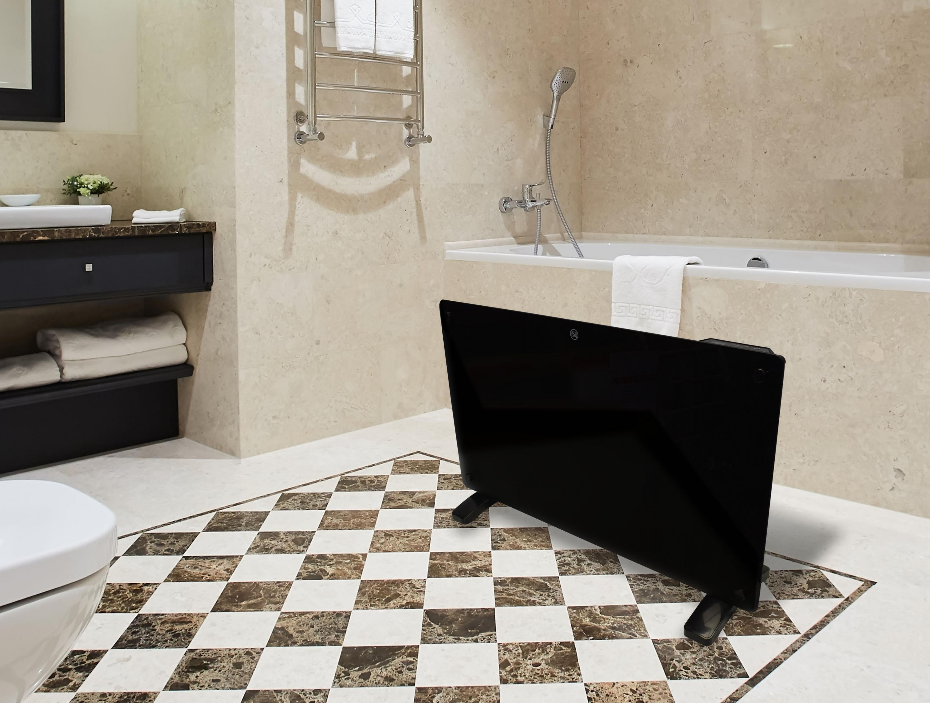 Un calefactor negro en un baño con una bañera blanca, un inodoro y un suelo estampado.