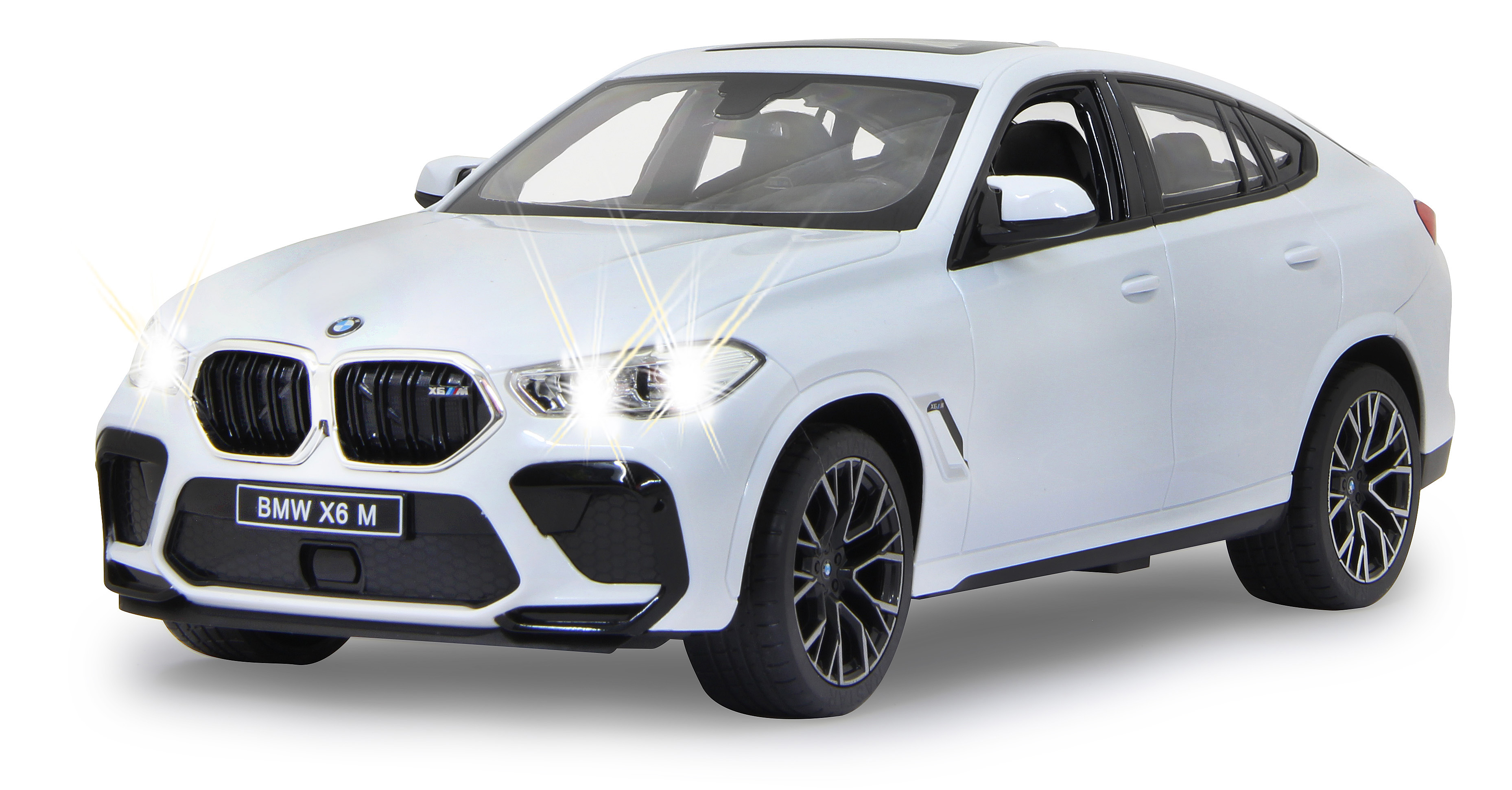 Weißes BMW X6 M Spielzeugauto mit eingeschaltetem Scheinwerfer. Das Auto hat schwarze Akzente und einen schwarzen Kühlergrill. Frontansicht.