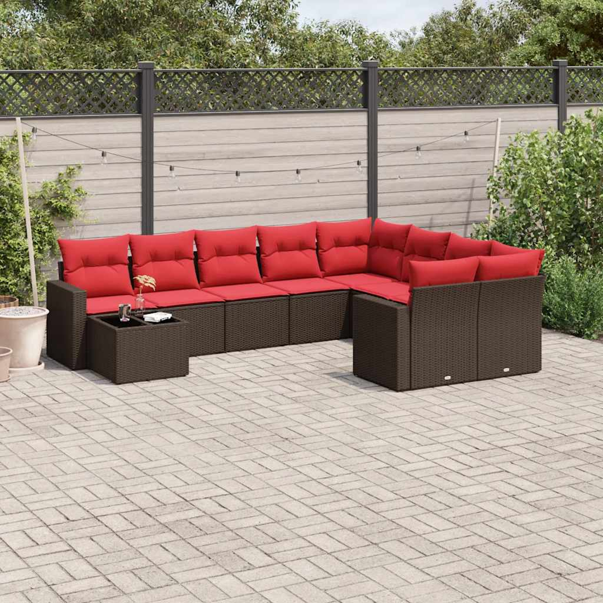 Ein Ecksofa im Freien mit roten Kissen und einem quadratischen Tisch in einer Backstein-Terrassenumgebung.