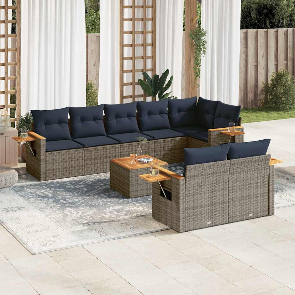 Outdoor-Korbsessel-Set mit blauen Kissen, einem Couchtisch und Beistelltischen. Weiße Vorhänge im Hintergrund.