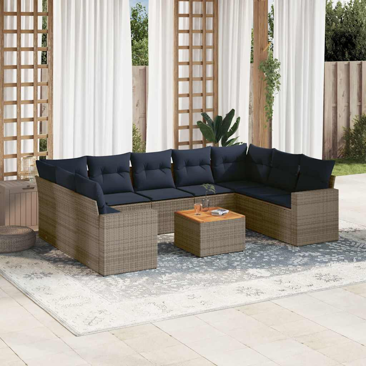 Ein hellbraunes Ecksofa aus Korbgeflecht mit blauen Kissen und einem kleinen Couchtisch auf einem Teppich im Freien.