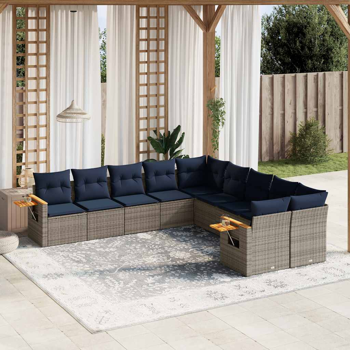 Ein graues Rattan-Ecksofa mit marinefarbenen Kissen und Holztischen.