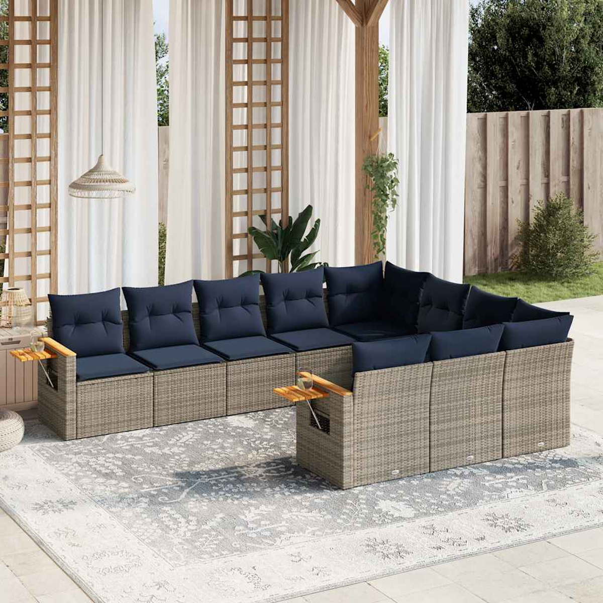 Ein graues Rattan-Ecksofa mit marinefarbenen Kissen und Holztischen.