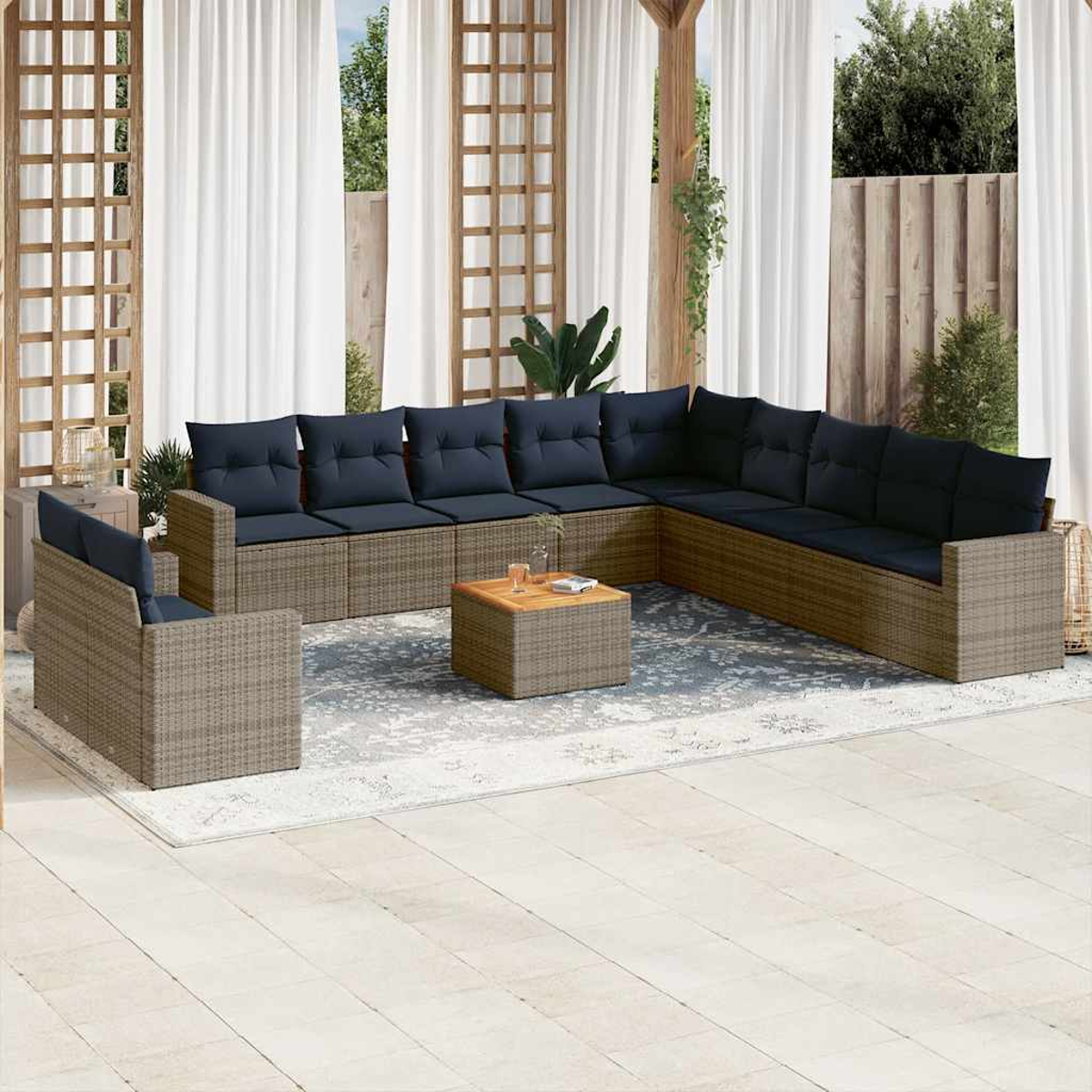 Gartensitzgruppe mit blauen Kissen. Enthält ein L-förmiges Sofa, einen Sessel und einen Tisch.