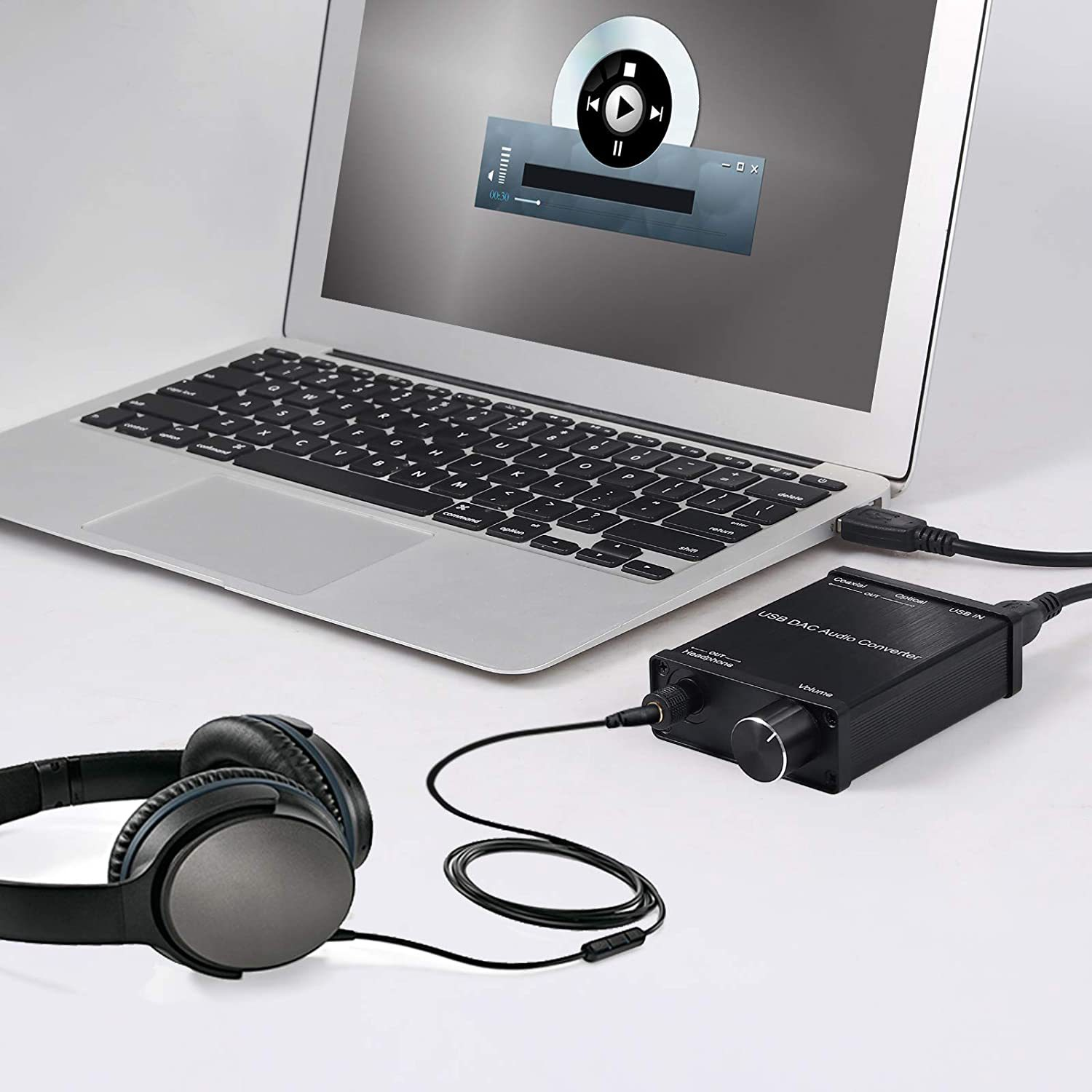 Ein Laptop, der mit einem schwarzen DAC und Kopfhörern verbunden ist, mit sichtbarer Musik-Player-Benutzeroberfläche.