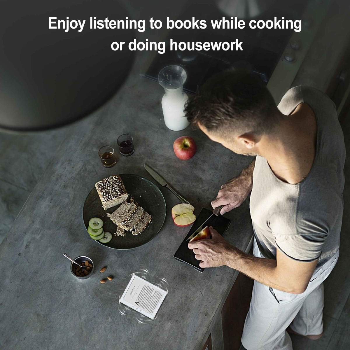 Eine Person schneidet einen Apfel auf einer Arbeitsplatte. Essen und ein Kindle sind in der Nähe.