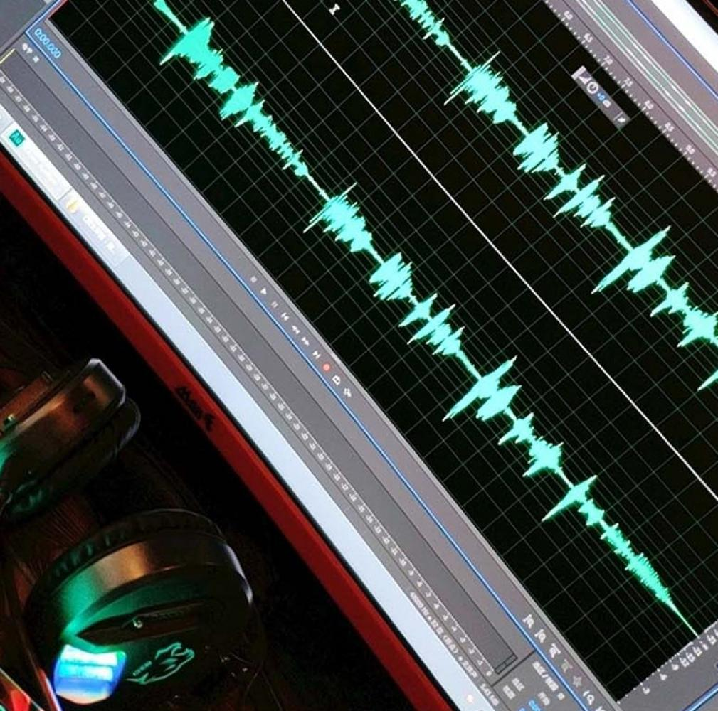 Ein Computerbildschirm mit Audio-Wellenformen, mit Kopfhörern im Vordergrund.