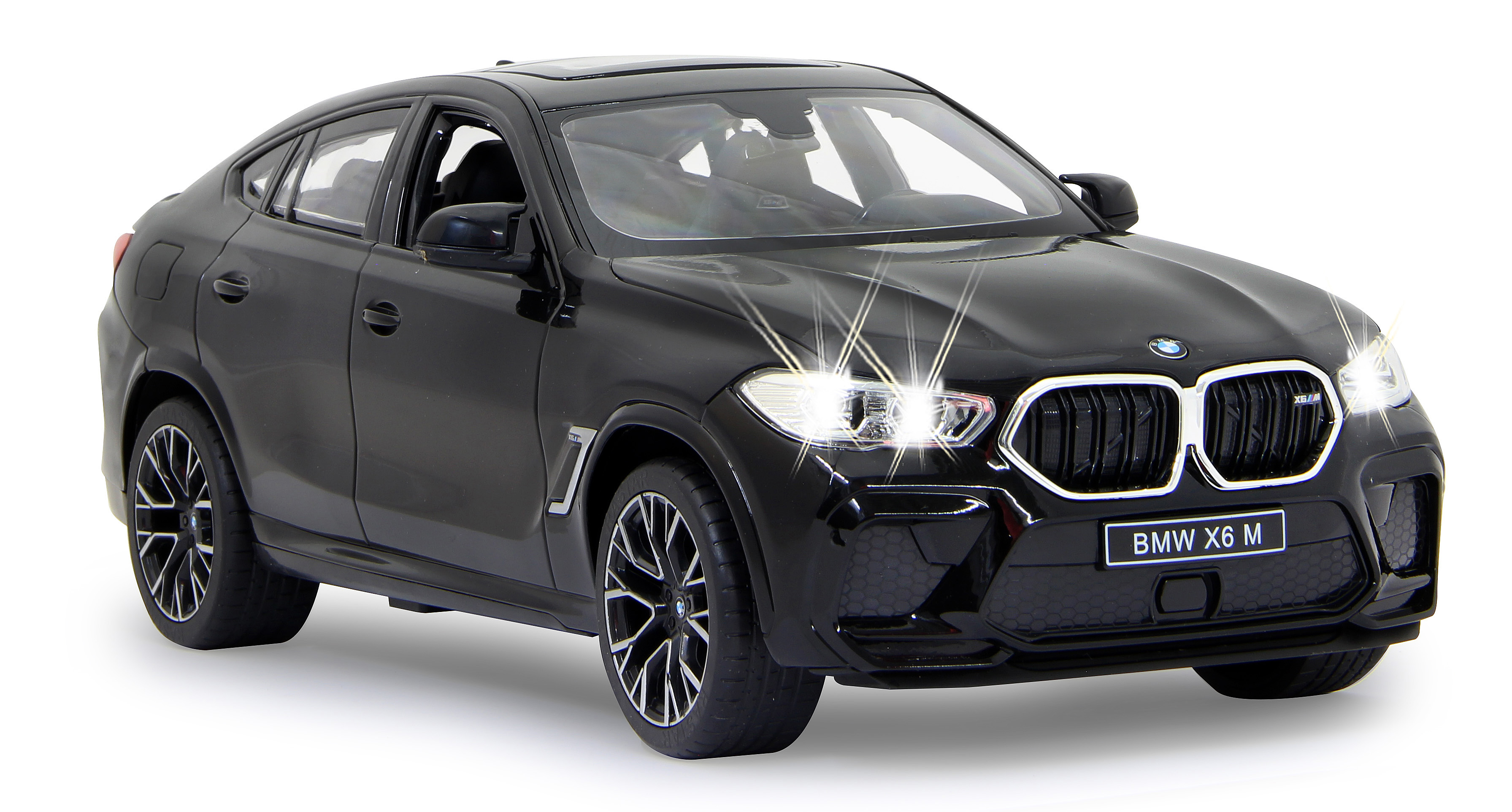 Schwarzes BMW X6 M Modellauto. Frontansicht mit eingeschalteten Scheinwerfern. Weißer Hintergrund.
