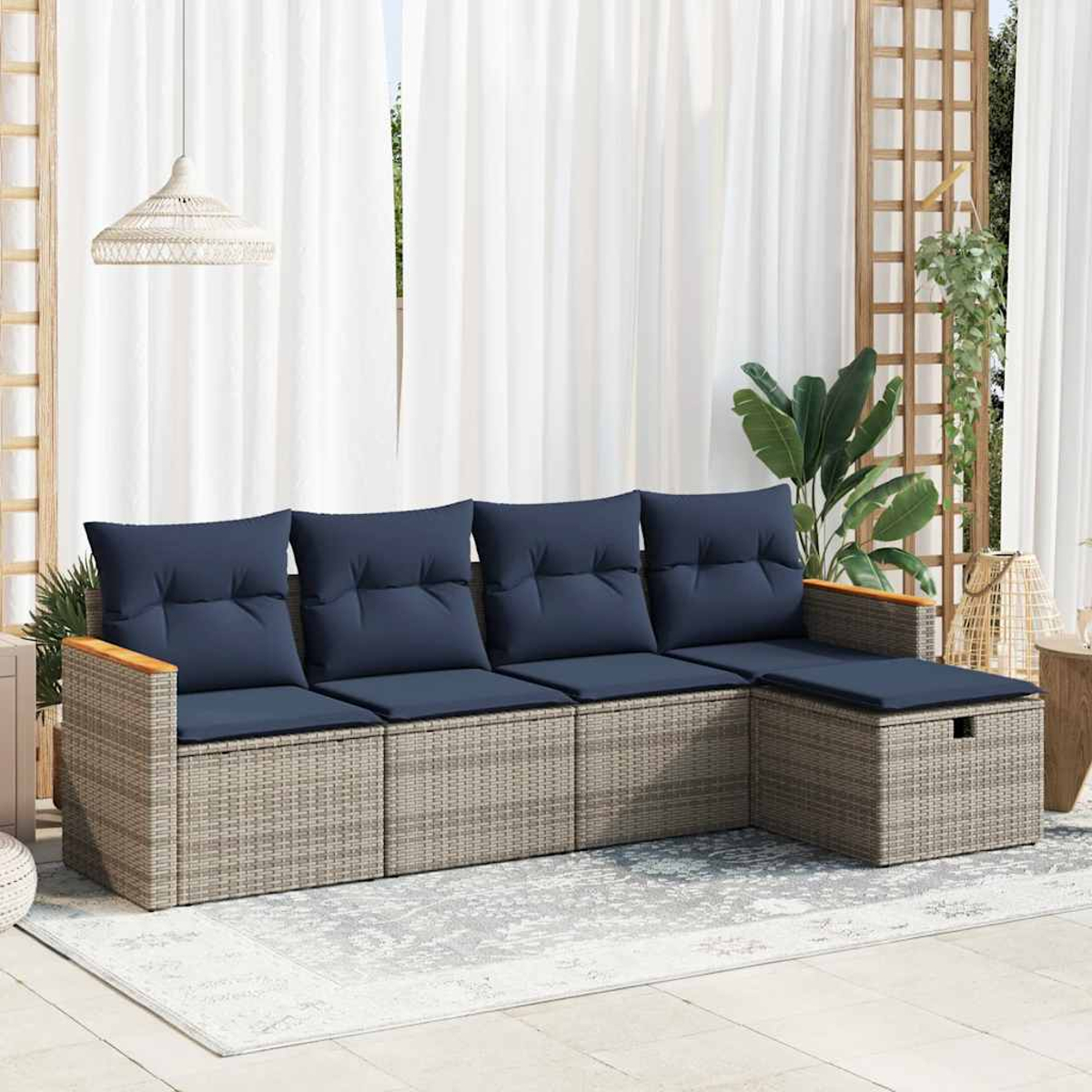 Beiges Rattansofa mit blauen Kissen, weißen Vorhängen und einer Hängeleuchte.