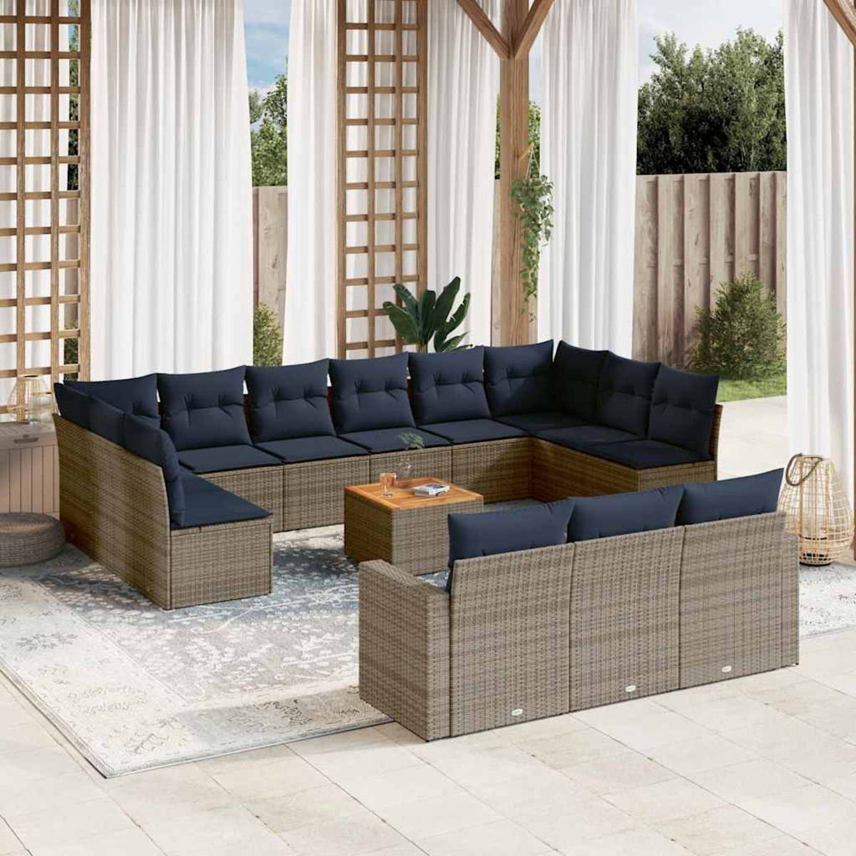 U-förmiges graues Rattansofa mit blauen Kissen, einem Holztisch und einem neutralen Teppich.
