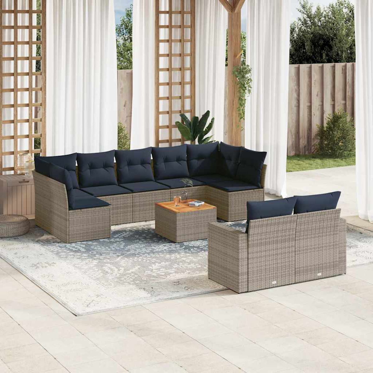 Ein Outdoor-Ecksofa mit blauen Kissen, einem Holztisch und einem Teppich auf einer Terrasse.