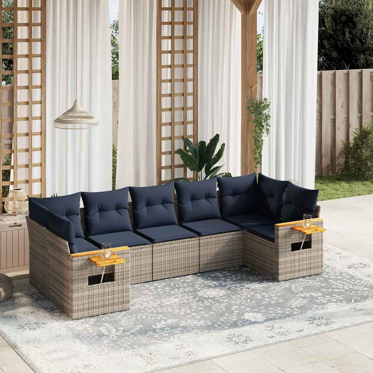 Rattan-Möbelset mit marineblauen Kissen und Beistelltischen mit Getränken. Das Set steht auf einer Terrasse.